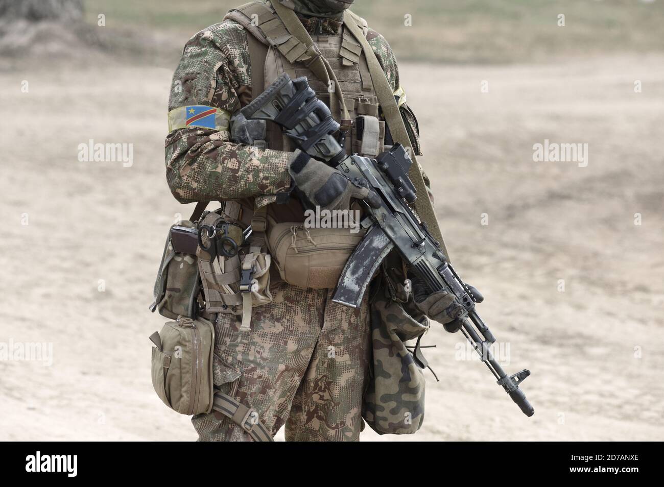 Soldier with machine gun and flag of Democratic Republic of the Congo on military uniform. Collage. Stock Photo