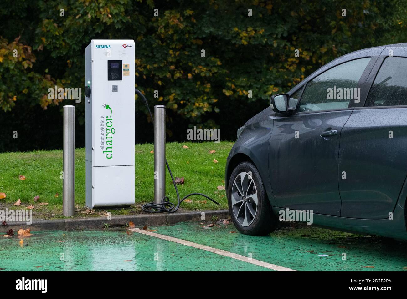 Electric car charging in car park, UK Stock Photo