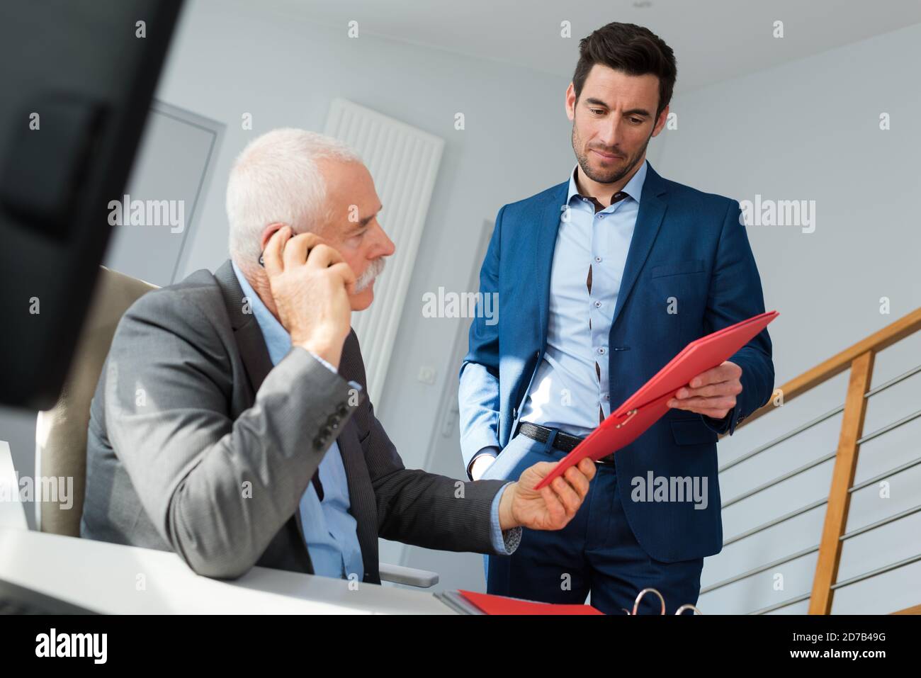 mature man and colleague working with his computer Stock Photo