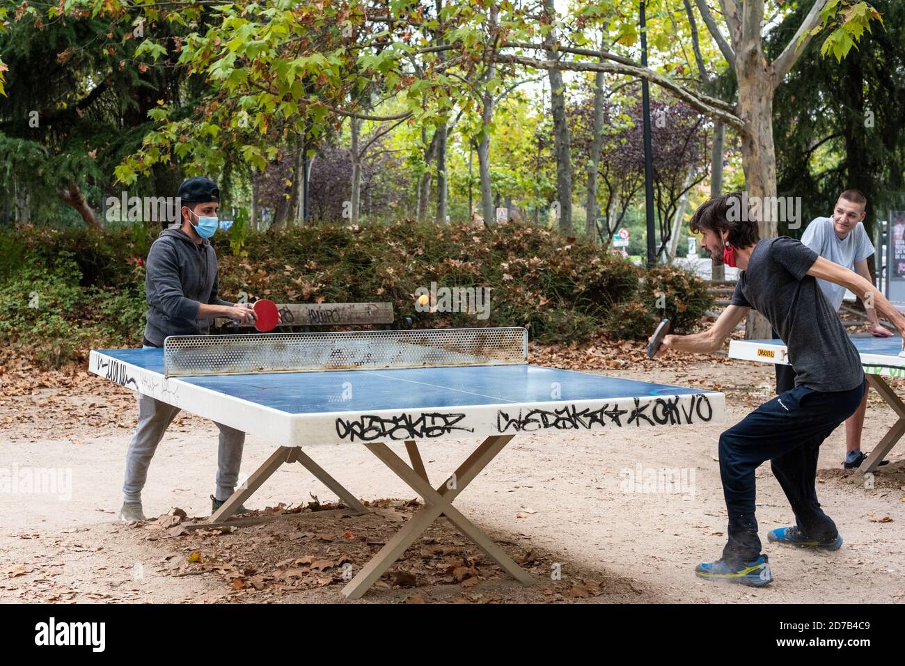 Two guys playing ping pong in a park in Madrid during COVID-19 pandemic.  They wear protective masks Stock Photo - Alamy