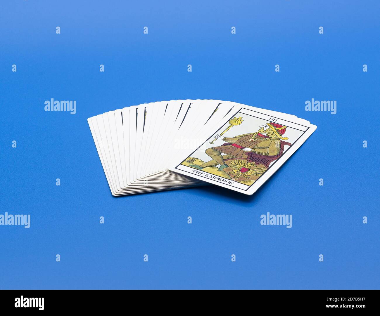 Pack of tarot cards with the Emperor card on the front isolated on a blue background Stock Photo