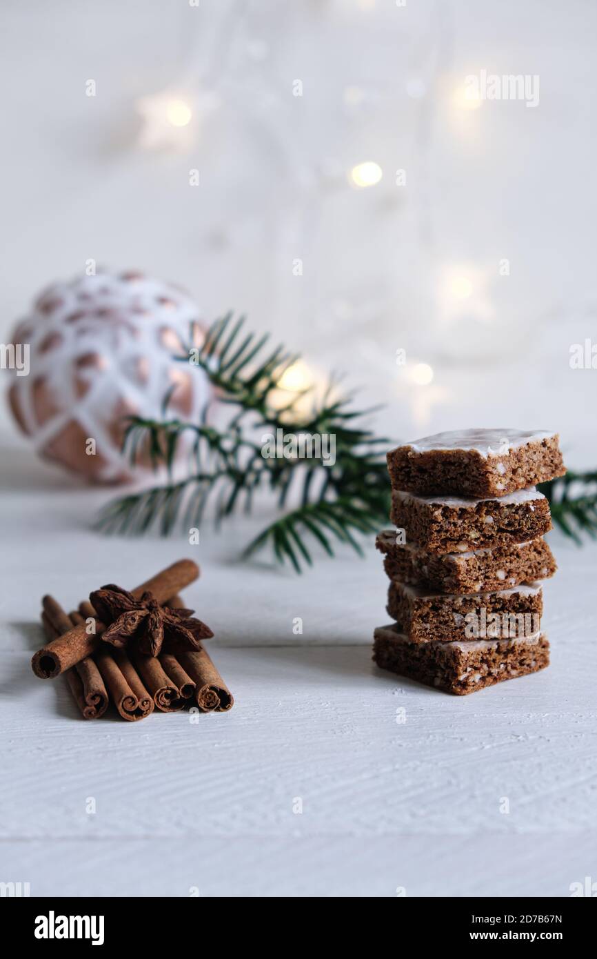 Advent and Christmas mood, honey cake stacked, beautifully decorated on a white wooden table in the background a white christmas ball and light Stock Photo