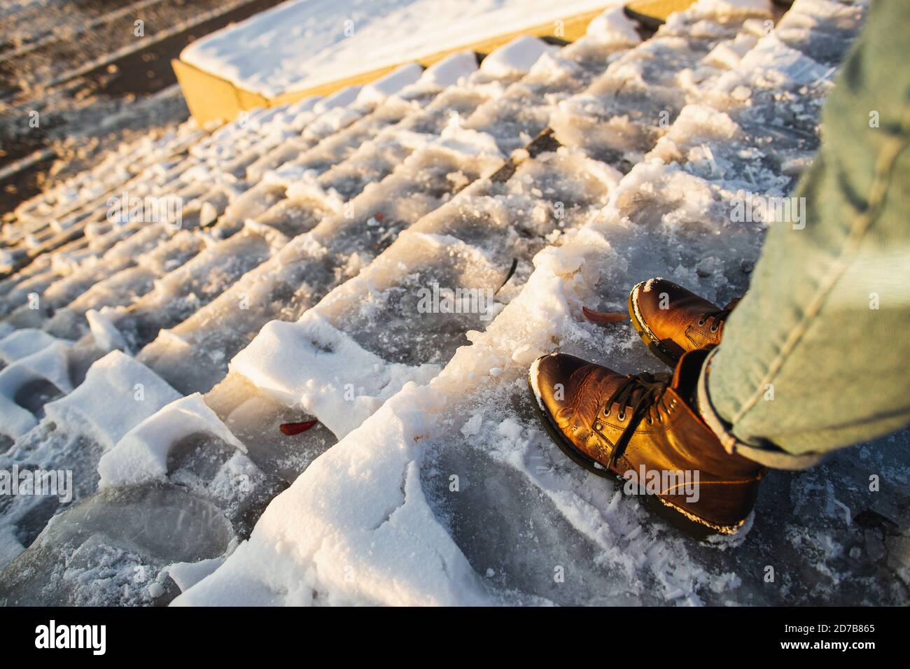 Danger of slipping. Female boots on rough slipper ice surface. A woman