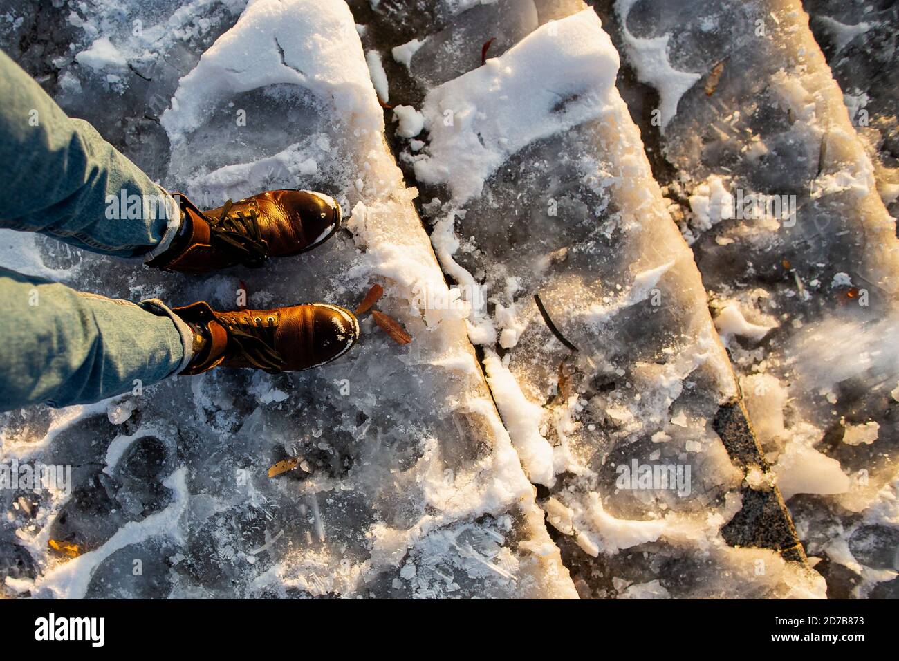 Danger of slipping. Female boots on rough slipper ice surface. A woman