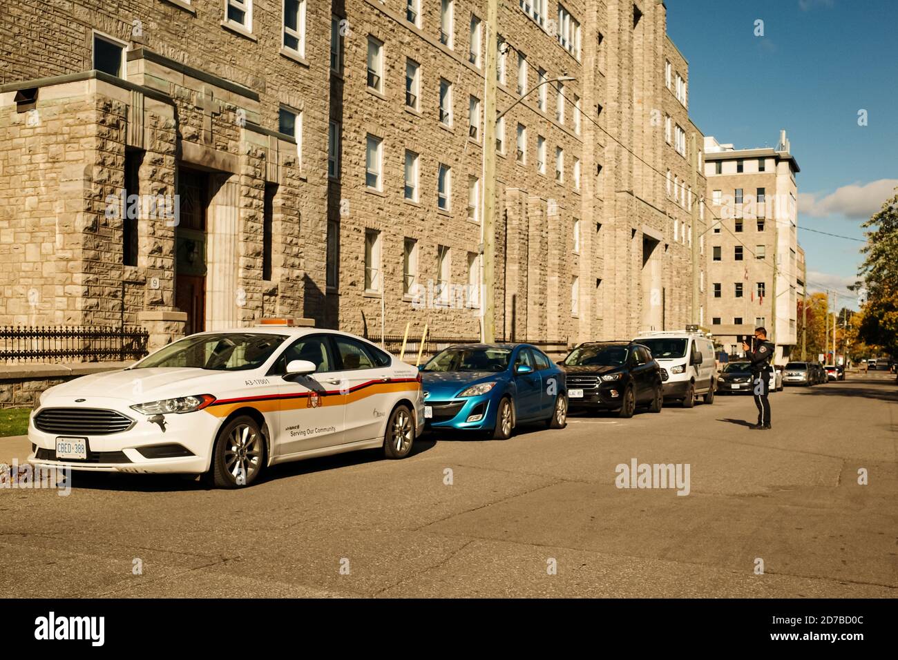 Ottawa, Ontario, Canada - October 8, 2020: A by-law officer with the City of Ottawa enforces parking restrictions. Stock Photo