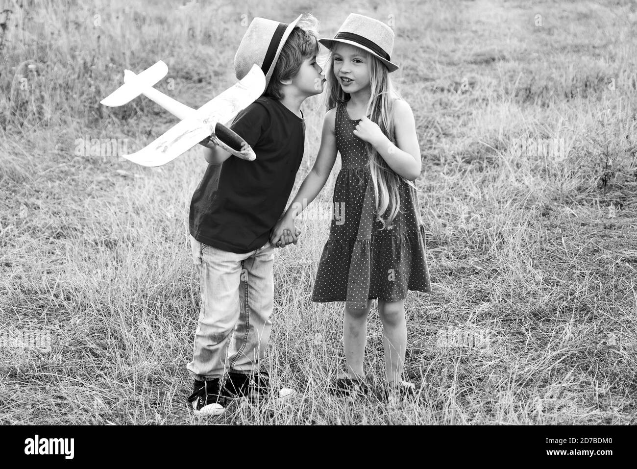 Kids kiss. Love story for cute children. Romantic and love. Childhood on countryside. Beautiful little couple - boy and girl embracing. Stock Photo