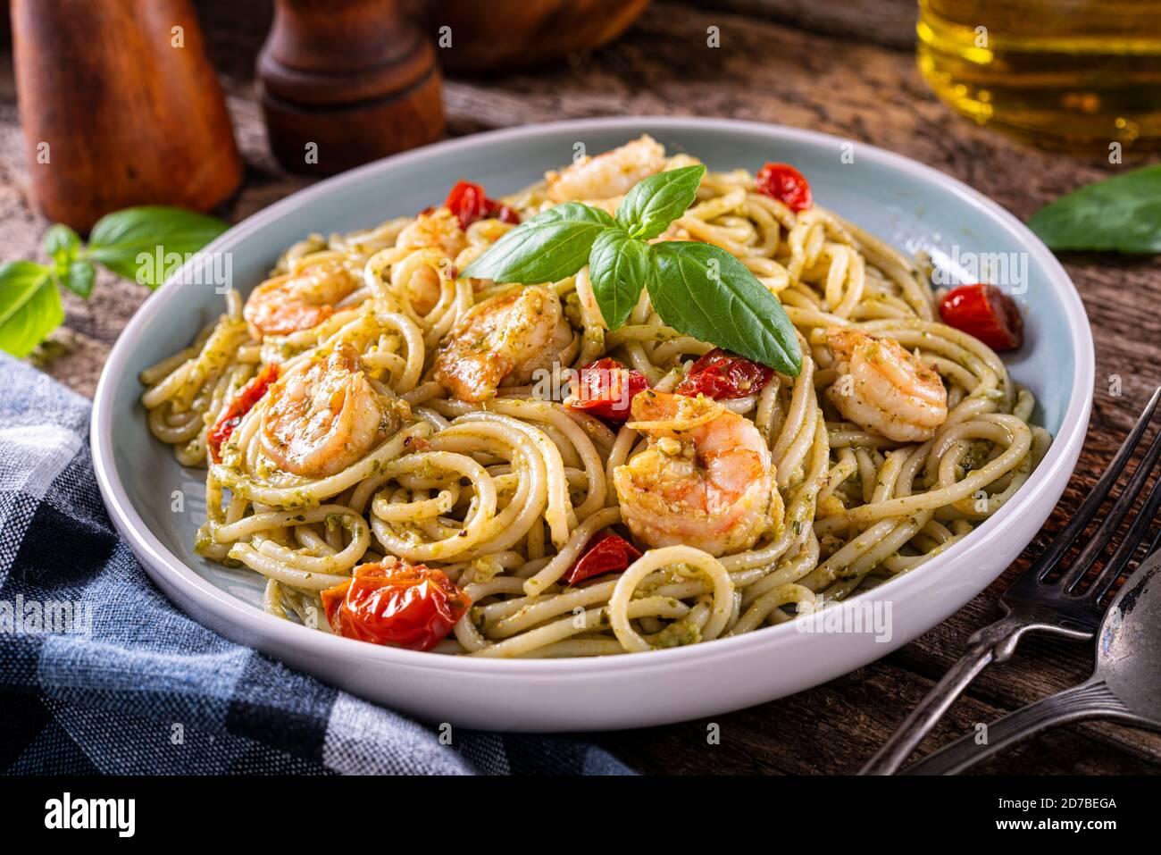 A plate of delicious shrimp pesto with basil, garlic, tomato, parmesan, olive oil and spaghetti. Stock Photo