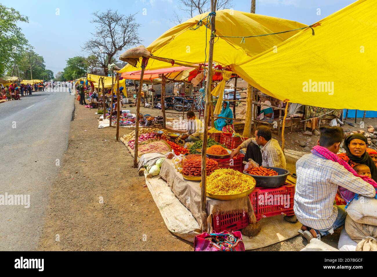 Stalls selling fresh local produce and steet food in a busy roadside market in a village in Madhya Pradesh, India Stock Photo