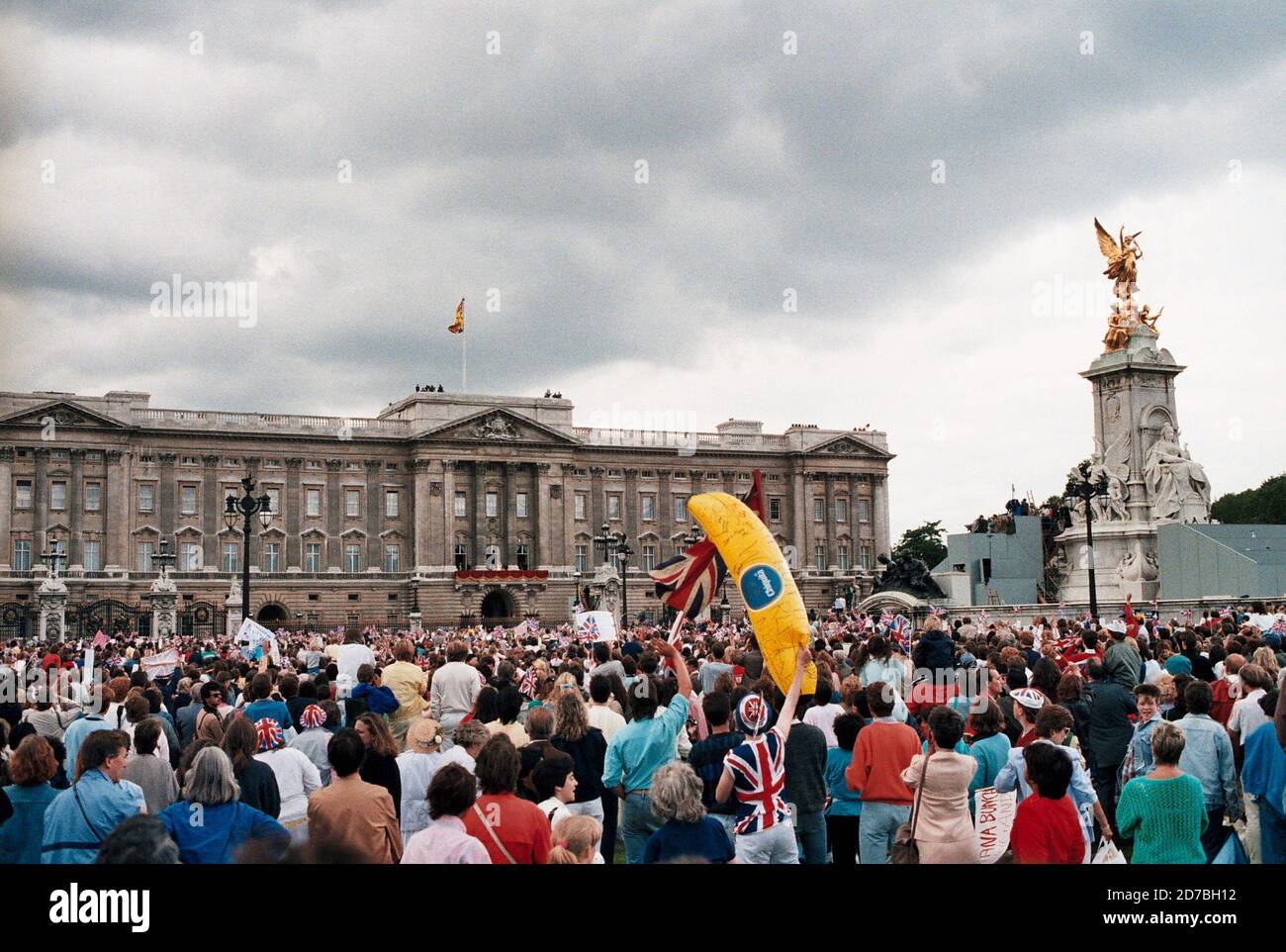 AJAXNETPHOTO. 23RD JULY, 1986. LONDON, ENGLAND. - CROWDS GATHER IN FRONT OF BUCKINGHAM PALACE TO SEE HRH PRINCE ANDREW AND SARAH FERGUSON - DUKE AND DUCHESS OF YORK -  WAVE TO CROWDS FROM PALACE BALCONY FOLLOWING THEIR WEDDING.  PHOTO: JONATHAN EASTLAND/AJAX REF:81403 1986 5 1 Stock Photo