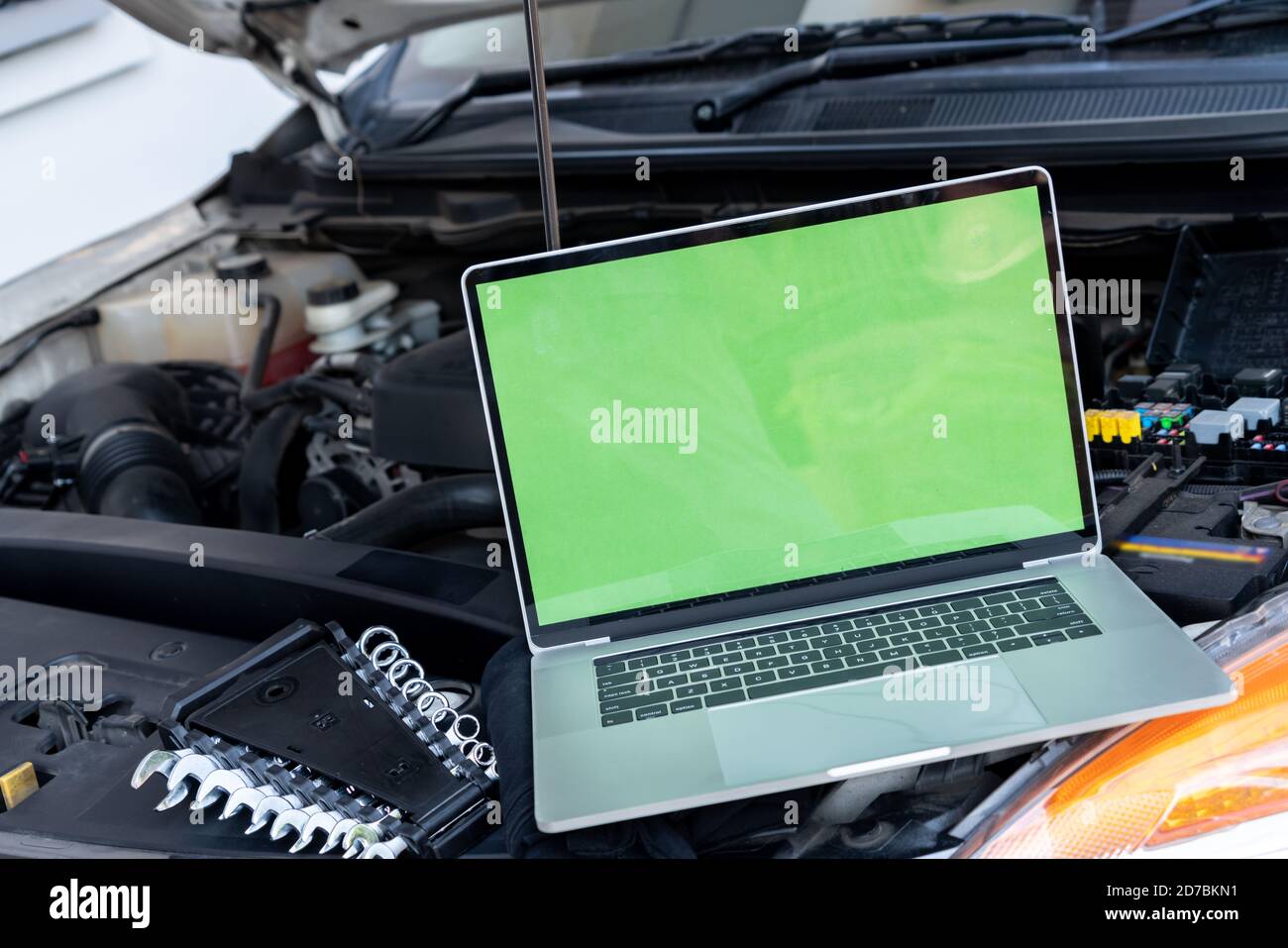 Laptop computer on car hood for engine diagnostic. Car garage repair