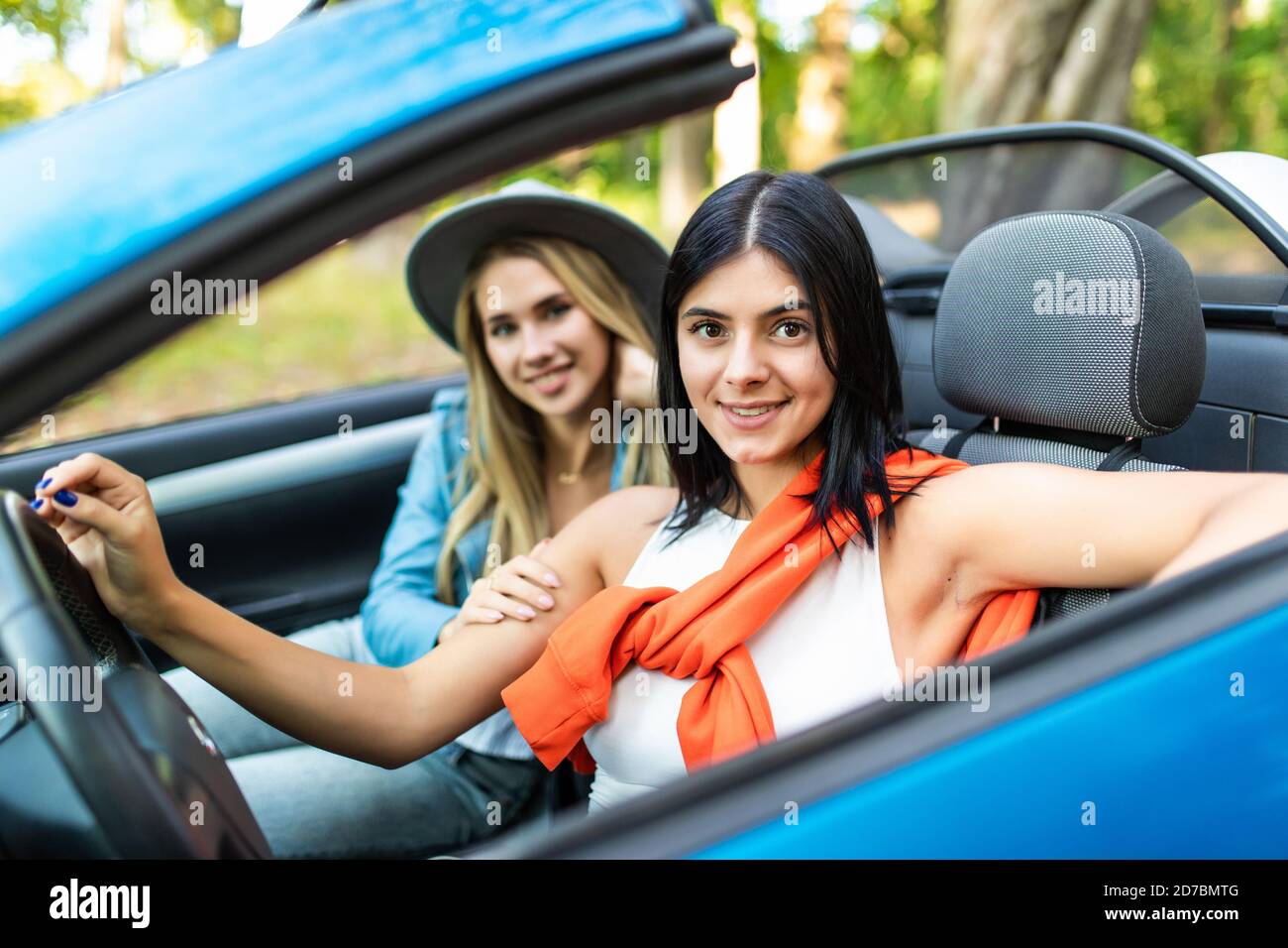 Two Female Friends Driving Open Top Car On Country Road Stock Photo - Alamy