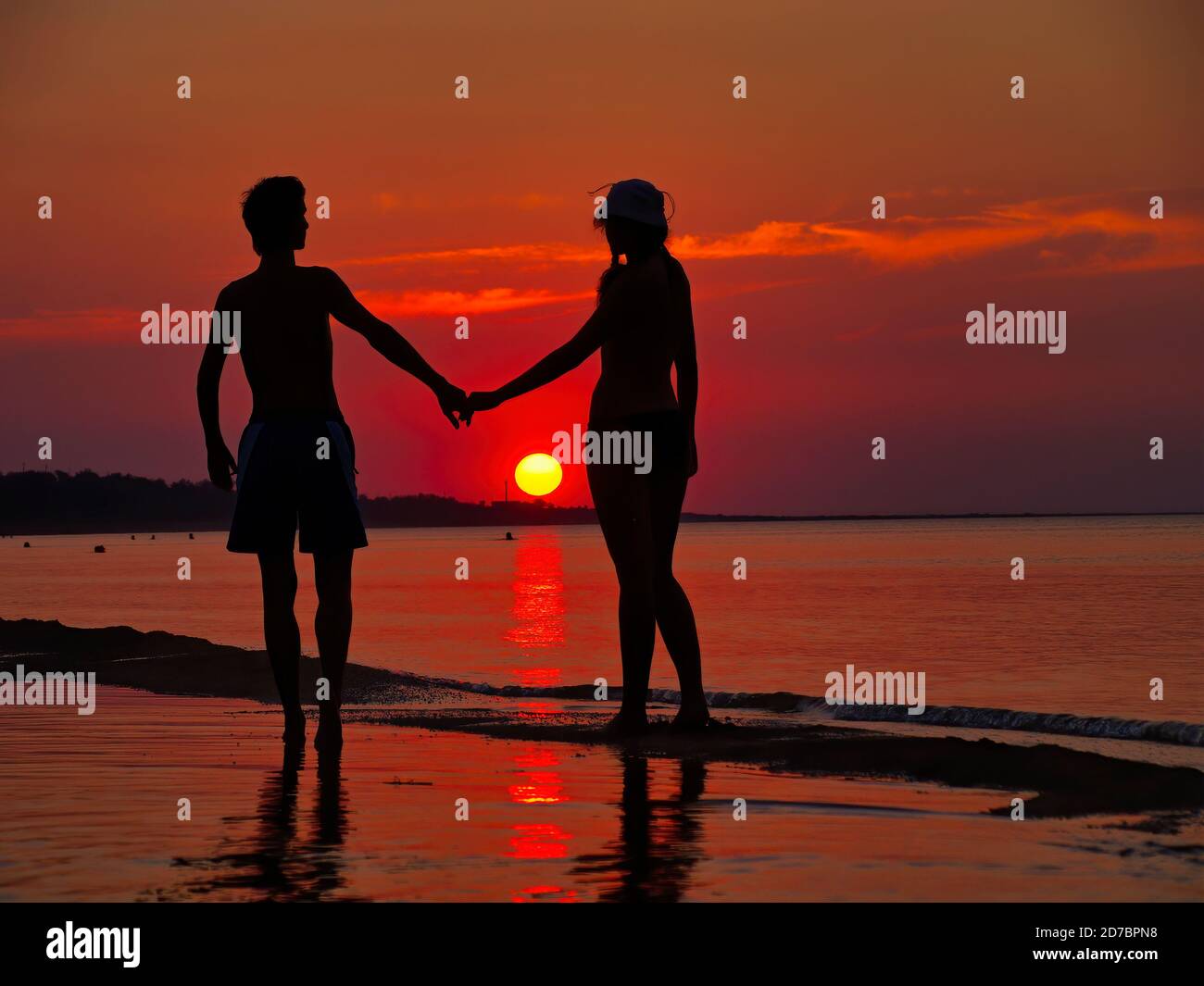 A couple in love holding hands on the beach at sunset Stock Photo - Alamy