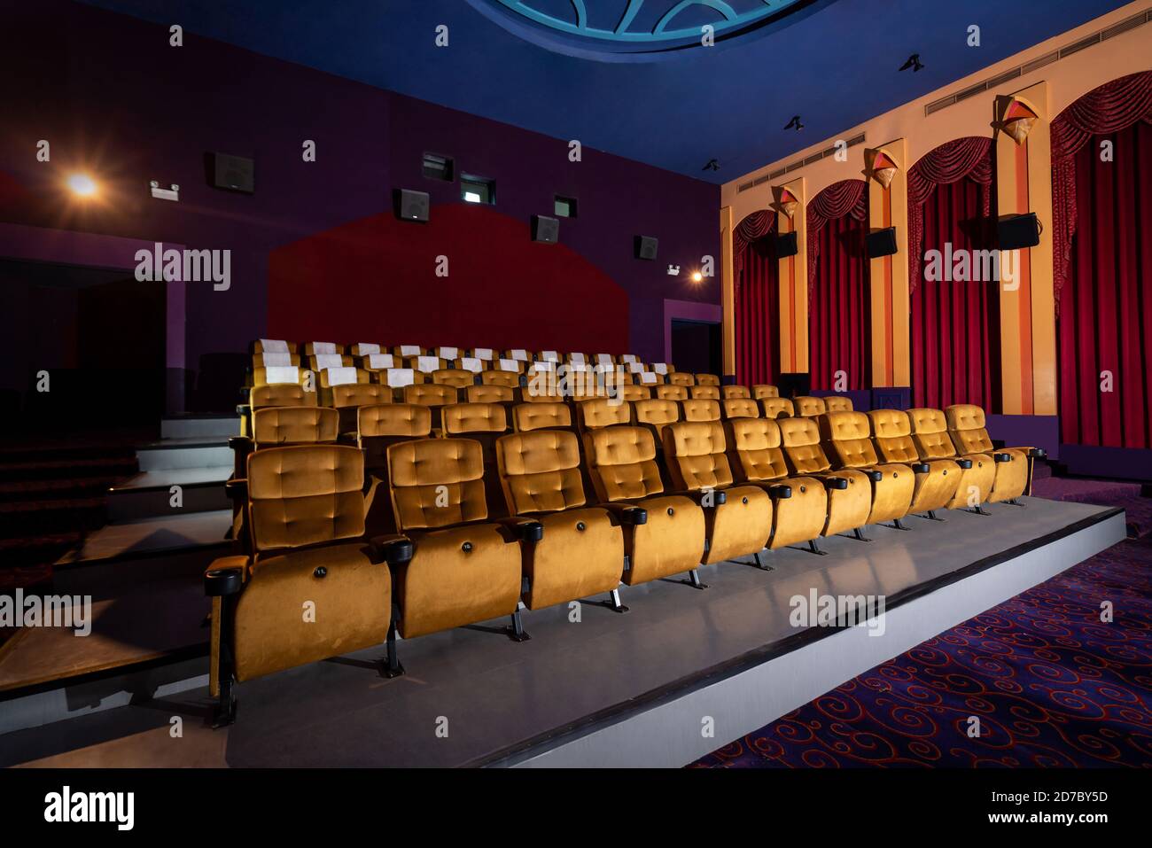 Large cinema theater interior with seat rows for audience to sit in movie theater premiere by cinematograph projector. The cinema theater is decorated Stock Photo