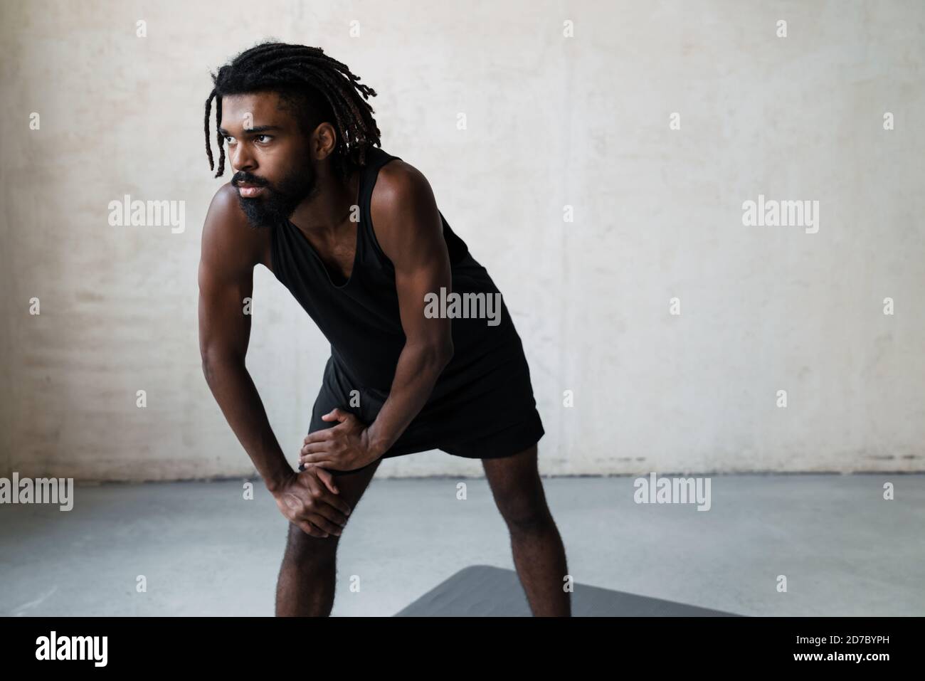 Image of young african american sportsman doing exercise while working out indoors Stock Photo