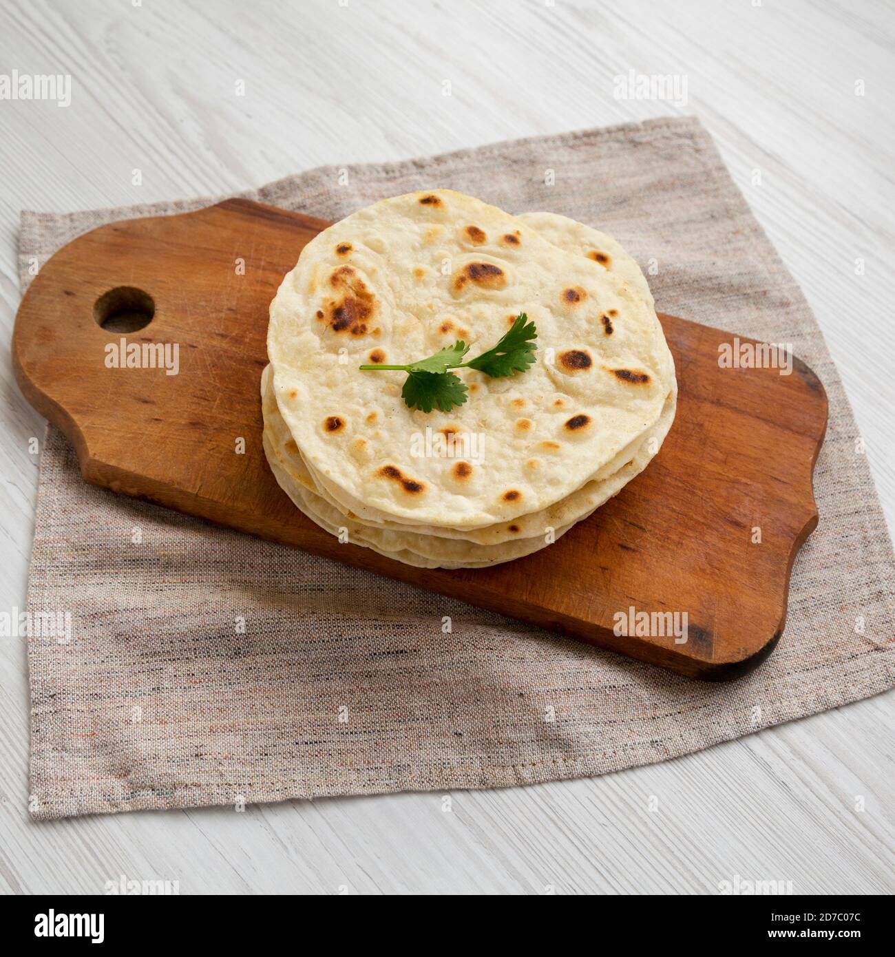 Homemade Roti Chapati Flatbread on a rustic wooden board on a white ...