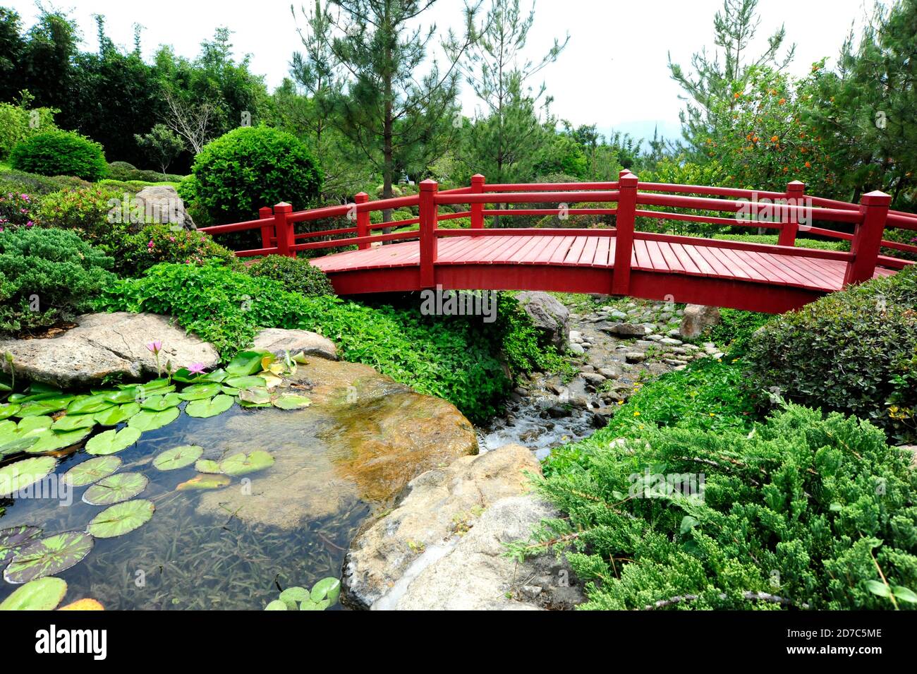 Photo of a Japanese garden red bridge over a small river Stock Photo ...