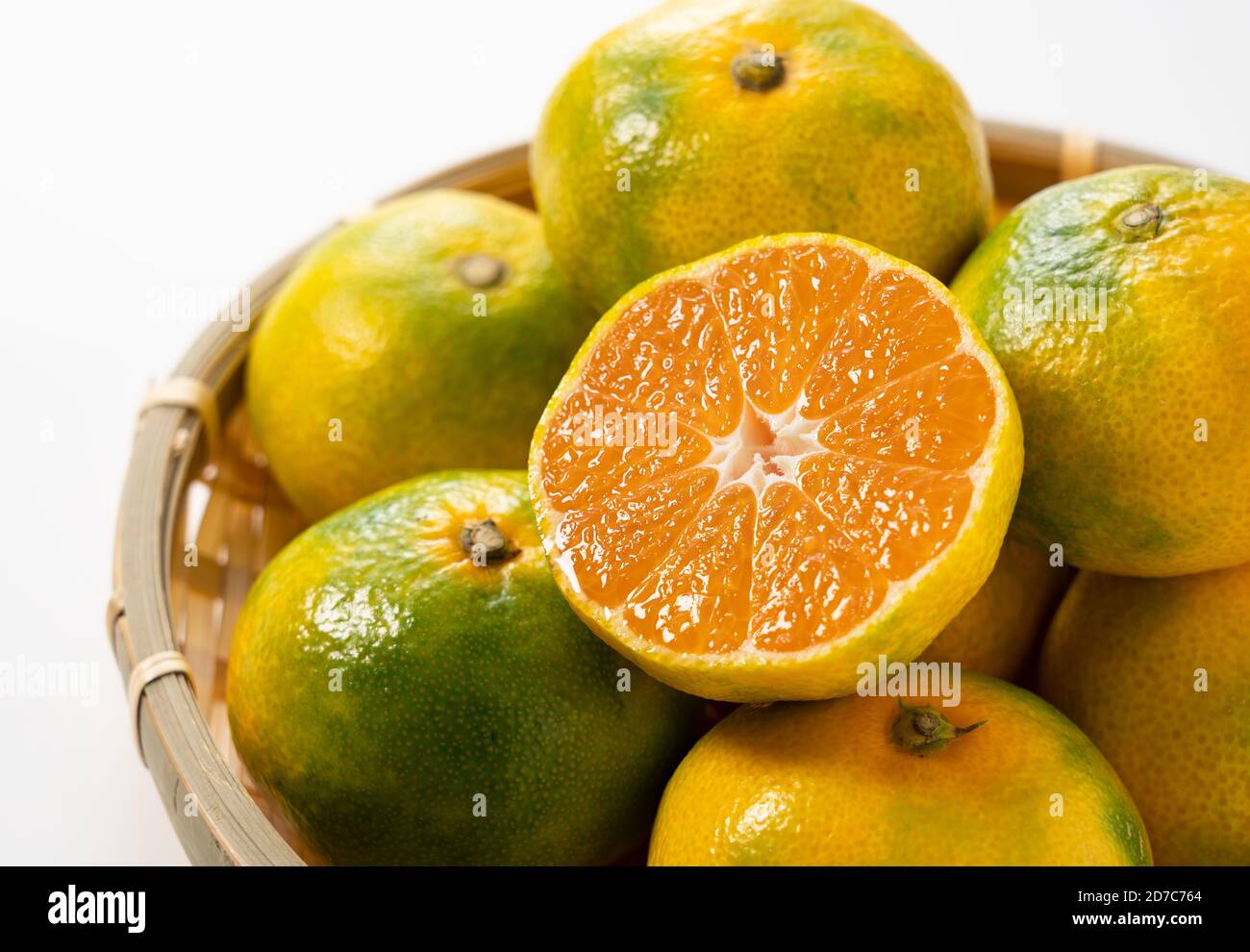 Early cut Japanese mandarin oranges on a colander Stock Photo Alamy