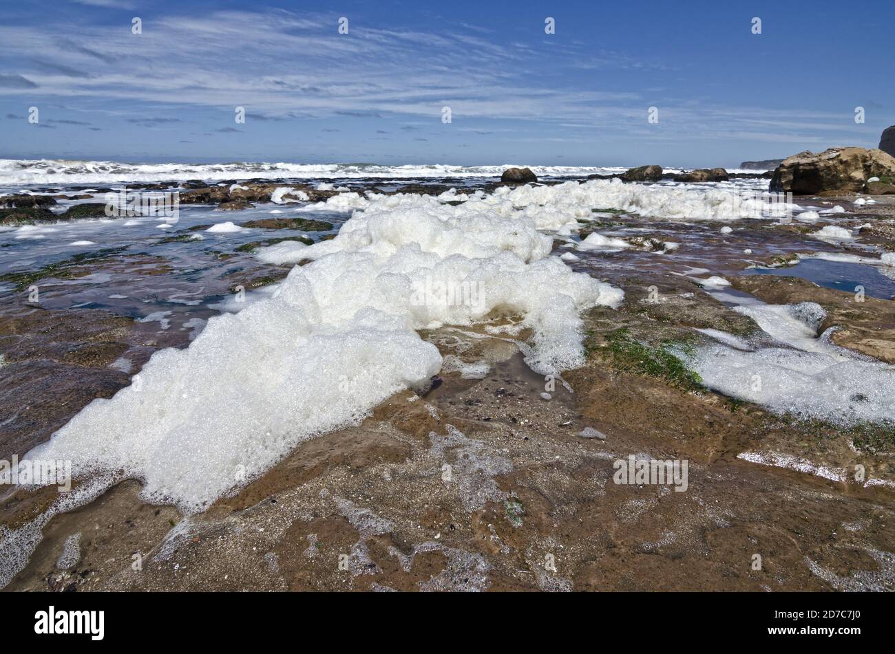 Landscape of rocks, waves, and foam in the seashore Stock Photo - Alamy