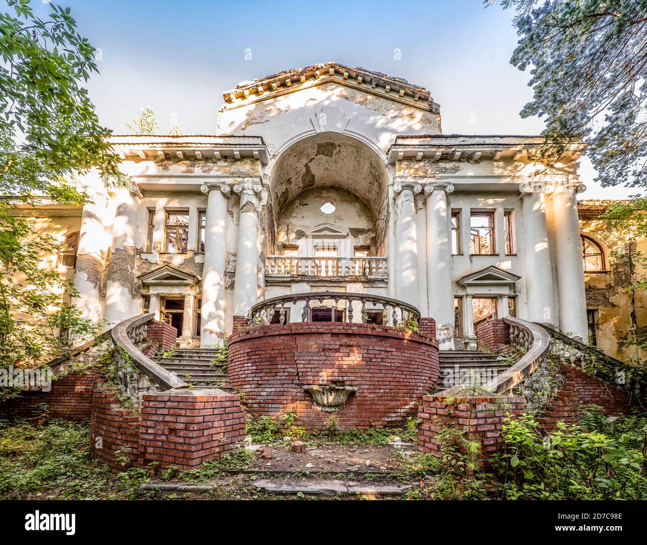 Abandoned dilapidated building in old park. Sweeping staircases ...