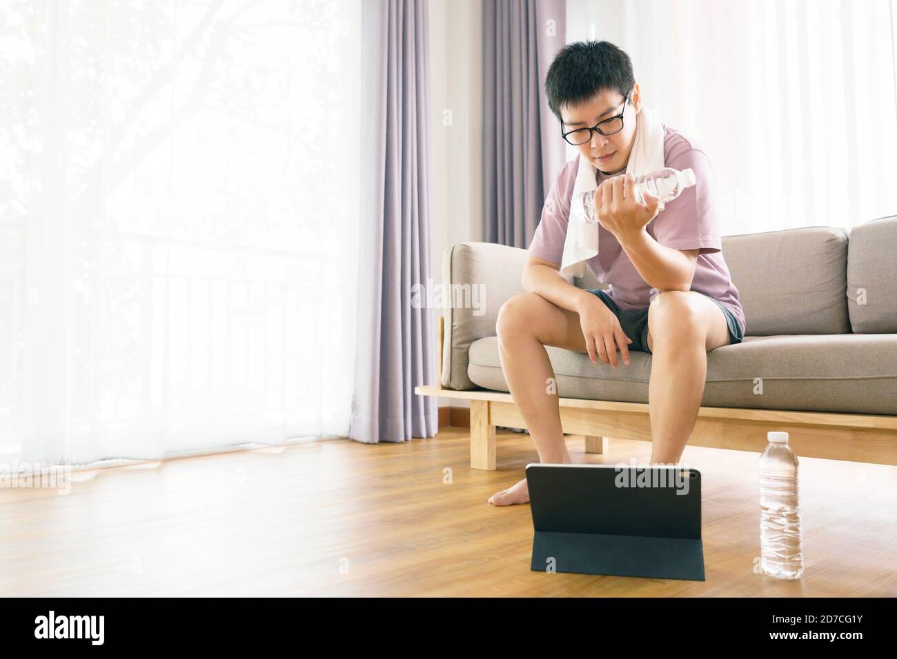 New normal Training At Home An Asian man, aged 35-40, with brown skin, Home exercise. exercising in living room. Stock Photo