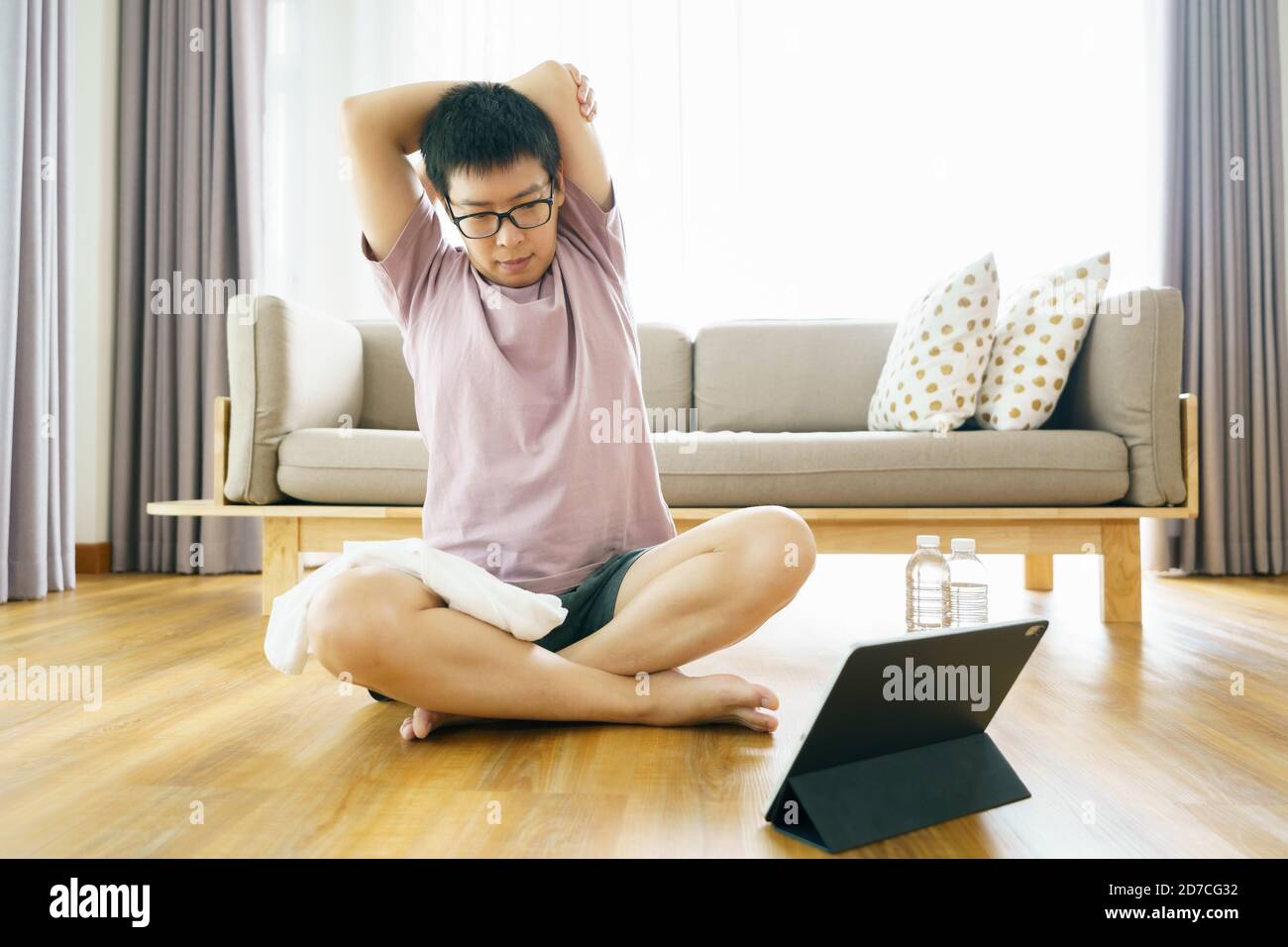 New normal Training At Home An Asian man, aged 35-40, with brown skin, Home exercise. exercising in living room. Stock Photo