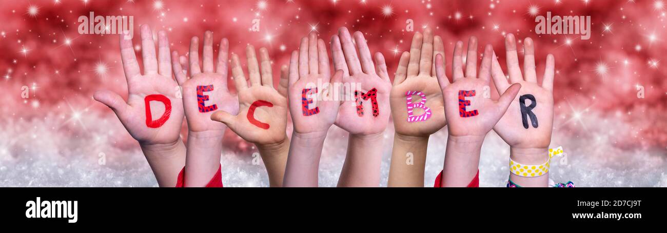 Children Hands Building Word December, Red Christmas Background Stock Photo