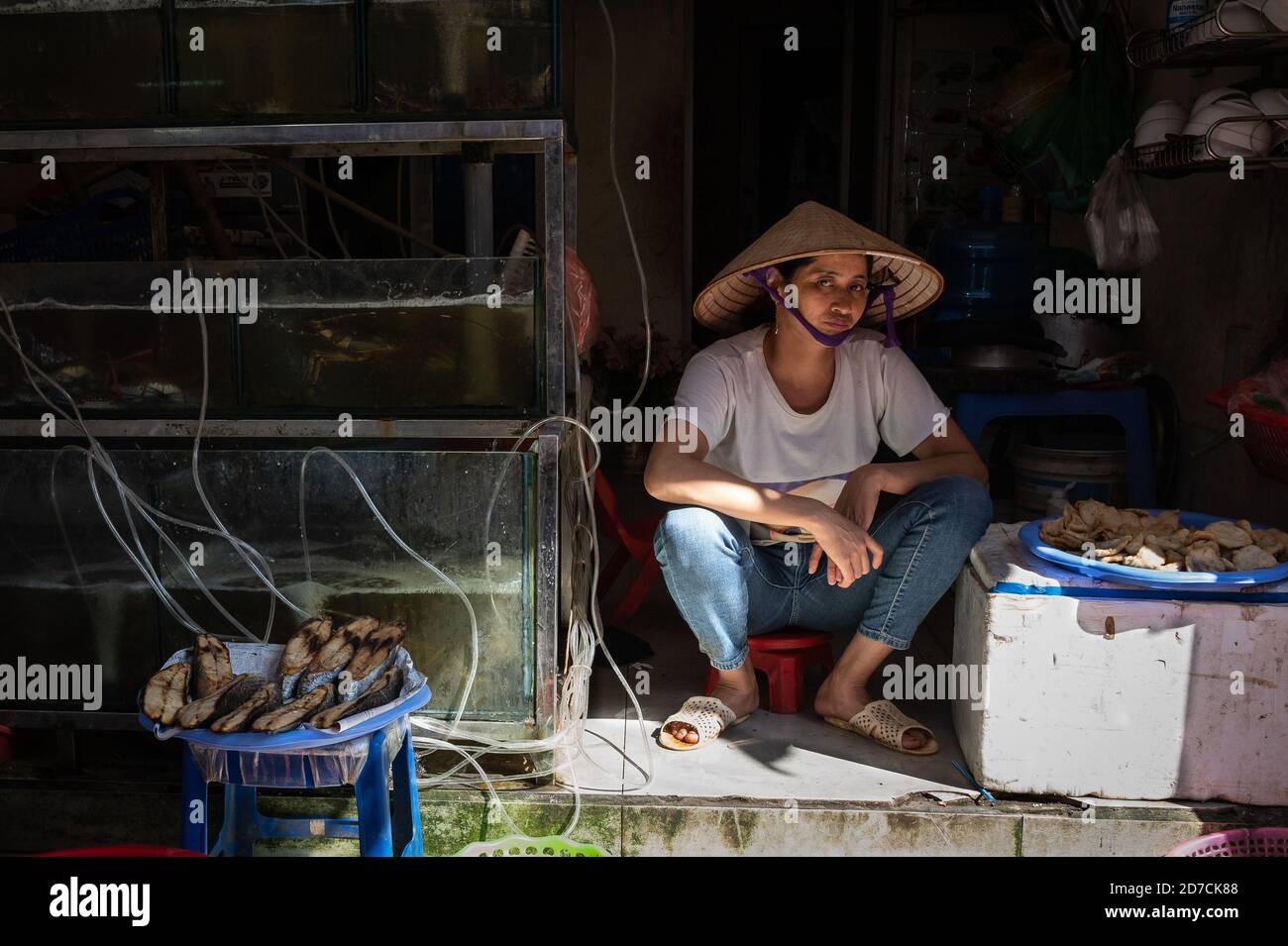 Vietnamese woman sitting in her shop, Hanoi, Vietnam. 10 October 2020 Stock Photo