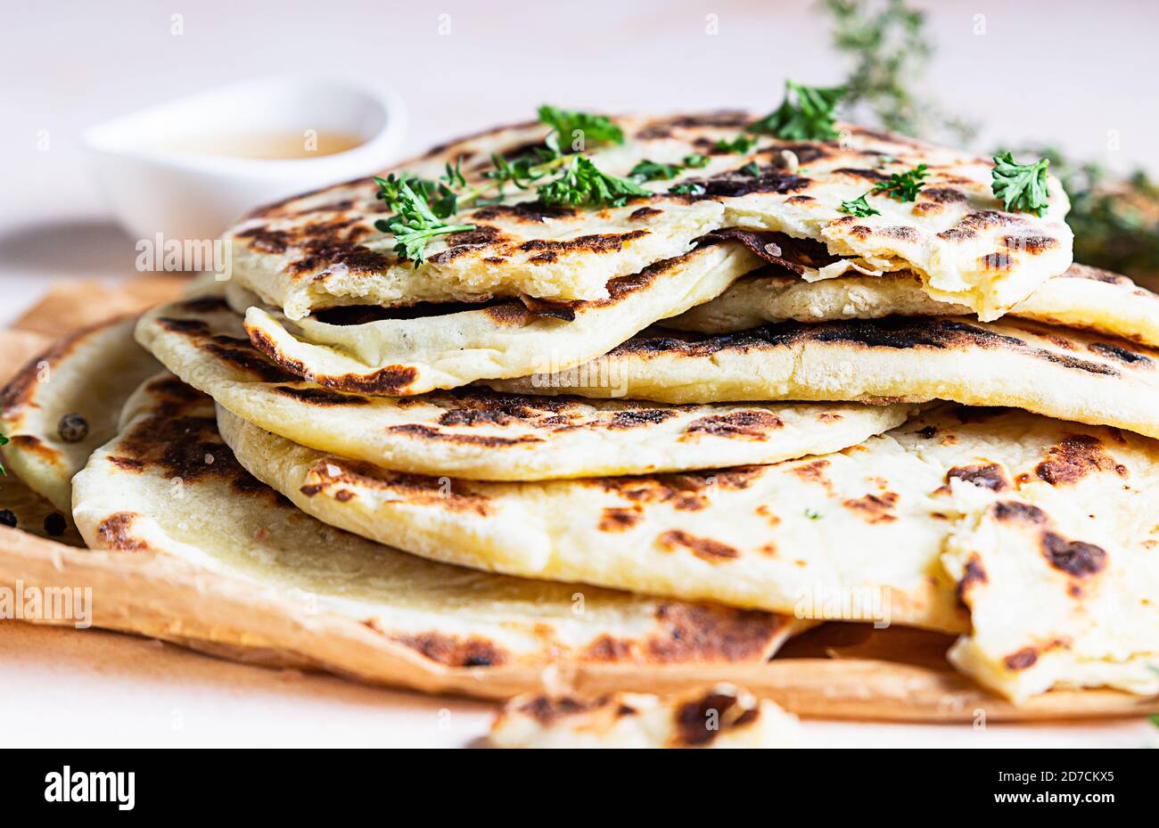 Indian homemade traditional flatbread with fresh parsley and olive oil. Chapati, roti or naan Indian crispy flatbread. Stock Photo