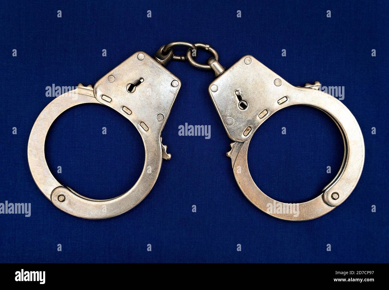 Handcuffs on the Blue Fabric Background closeup Stock Photo Alamy