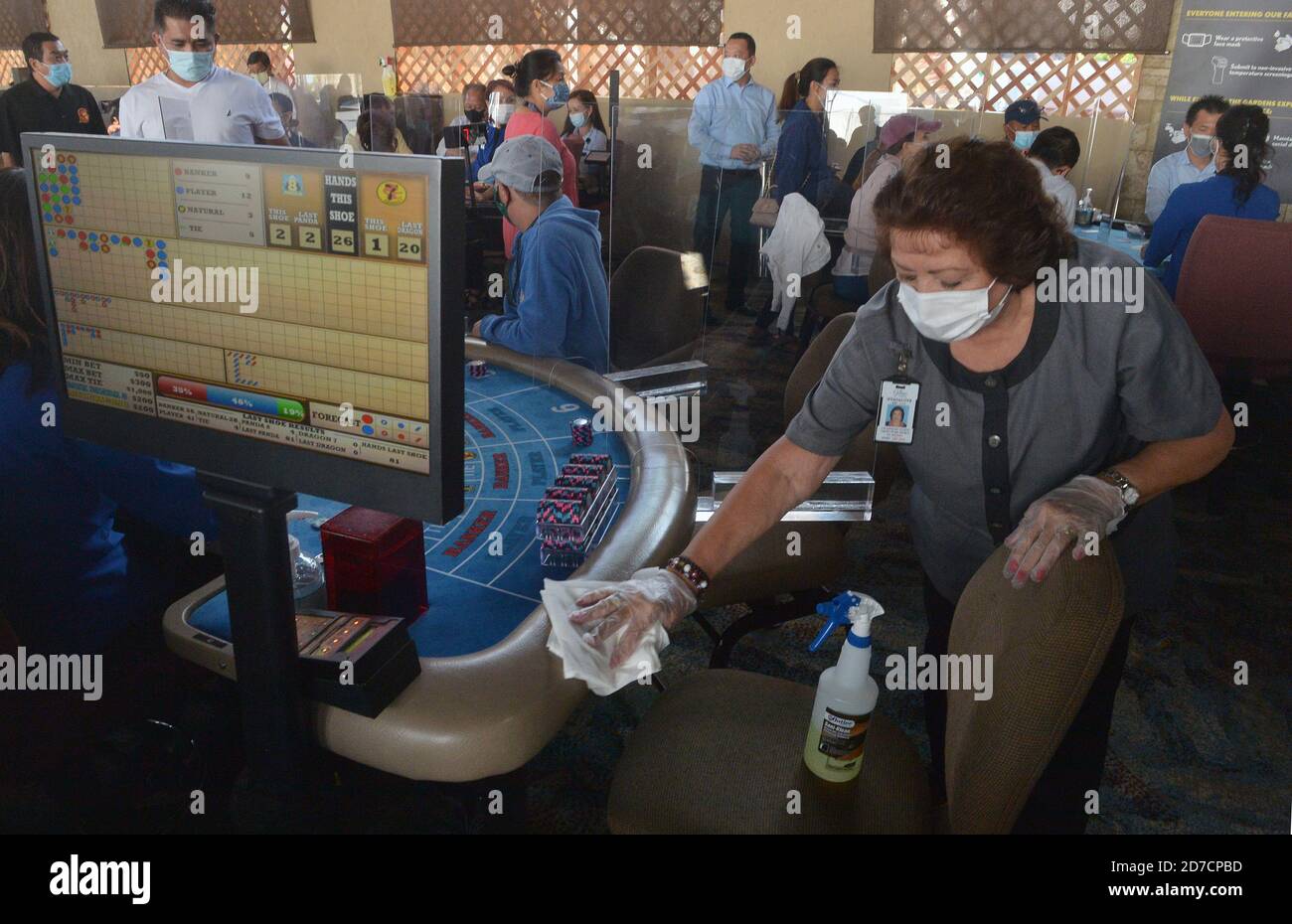 Hawaiian Gardens, United States. 22nd Oct, 2020. A worker sanitizes one of 45 card tables in what used to be the valet area of Gardens Casino in Hawaiian Gardens, California on Wednesday, October 21, 2020. Partitions and seats are sanitized each time a customer gets up tp prevent the spread of the coronavirus. Card clubs in Los Angeles County reopened in early October with health precautions, drawing a stream of gamblers and expressions of relief from city leaders who have struggled without the key source of tax revenue. Photo by Jim Ruymen/UPI Credit: UPI/Alamy Live News Stock Photo