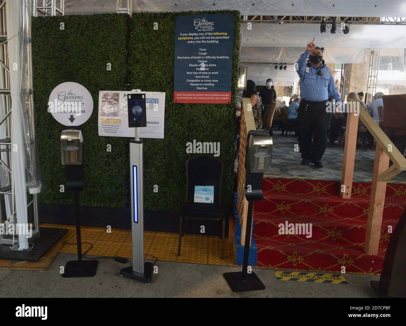 Hawaiian Gardens, United States. 22nd Oct, 2020. A sign informs patrons they cannot enter if they have any of the COVID-19 symptoms listed to what used to be the valet area of Gardens Casino in Hawaiian Gardens, California on Wednesday, October 21, 2020. Partitions and seats are sanitized each time a customer gets up. Card clubs in Los Angeles County reopened in early October with health precautions, drawing a stream of gamblers and expressions of relief from city leaders who have struggled without the key source of tax revenue. Photo by Jim Ruymen/UPI Credit: UPI/Alamy Live News Stock Photo