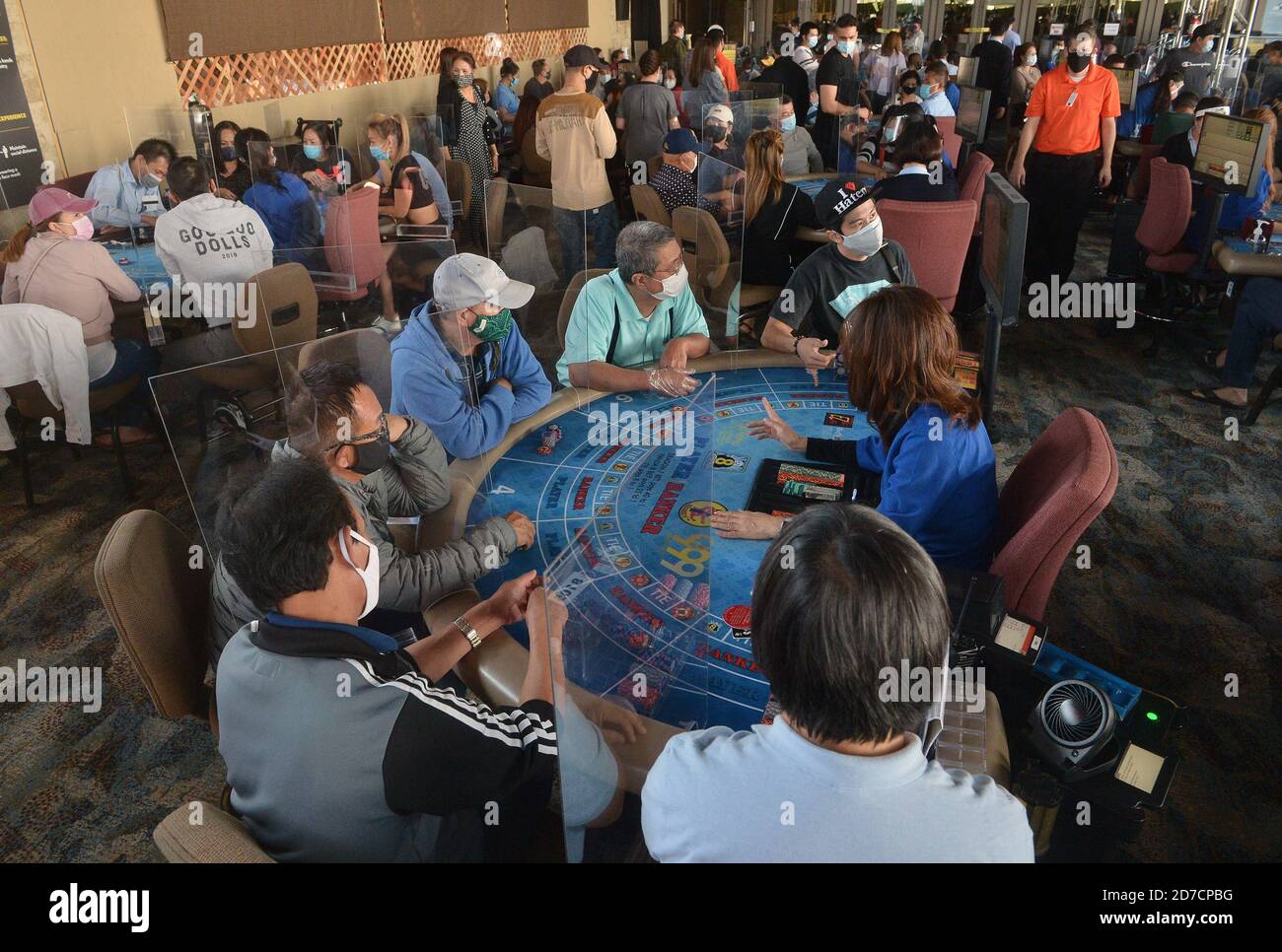 Hawaiian Gardens, United States. 22nd Oct, 2020. Patrons gather at one of 45 card tables in what used to be the valet area of Gardens Casino in Hawaiian Gardens, California on Wednesday, October 21, 2020. Partitions and seats are sanitized each time a customer gets up to prevent the spread of the coronavirus. Card clubs in Los Angeles County reopened in early October with health precautions, drawing a stream of gamblers and expressions of relief from city leaders who have struggled without the key source of tax revenue. Photo by Jim Ruymen/UPI Credit: UPI/Alamy Live News Stock Photo