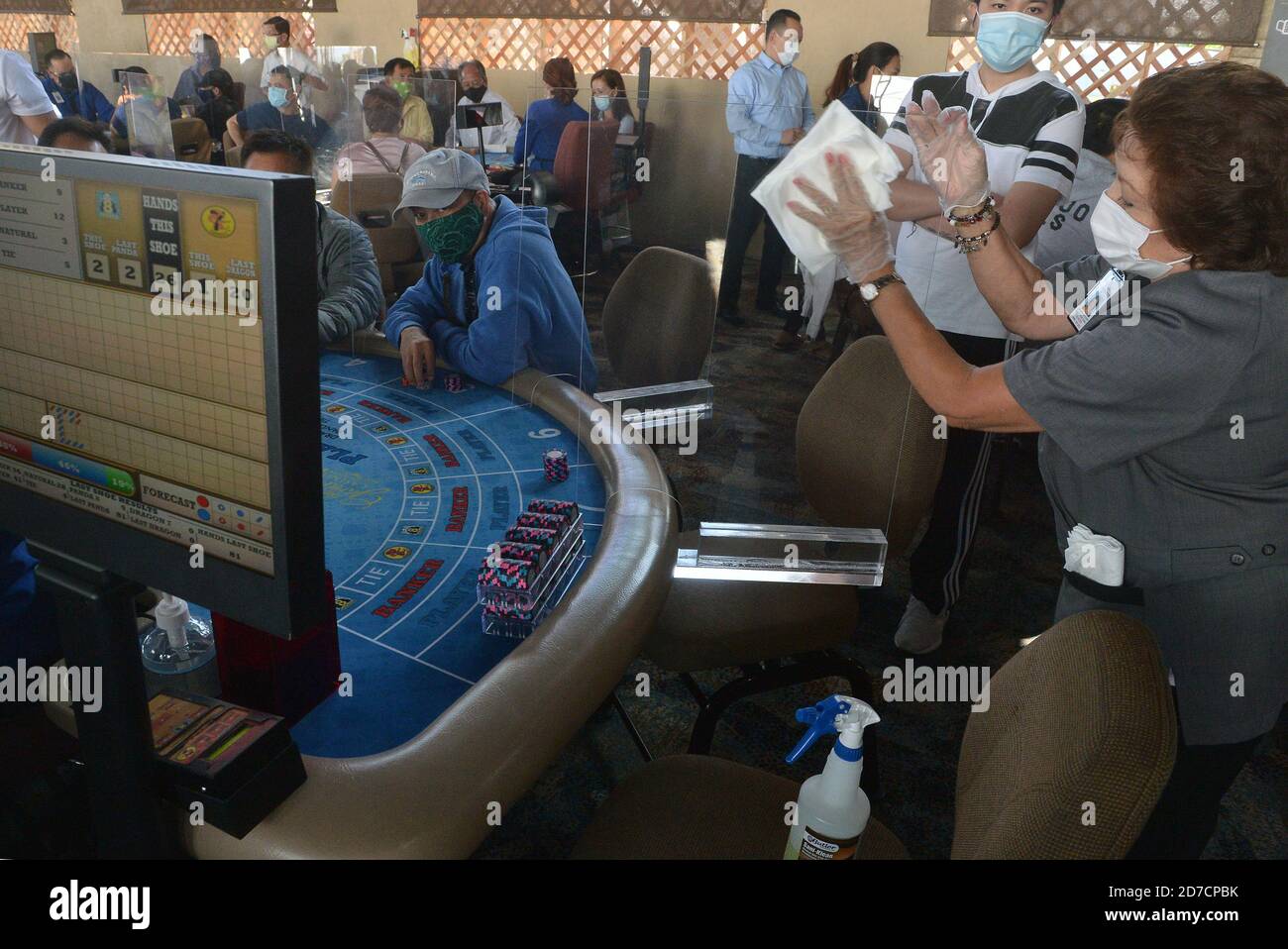 Hawaiian Gardens, United States. 22nd Oct, 2020. A worker sanitizes a partition at one of 45 card tables in what used to be the valet area of Gardens Casino in Hawaiian Gardens, California on Wednesday, October 21, 2020. Partitions and seats are sanitized each time a customer gets up tp prevent the spread of the coronavirus. Card clubs in Los Angeles County reopened in early October with health precautions, drawing a stream of gamblers and expressions of relief from city leaders who have struggled without the key source of tax revenue. Photo by Jim Ruymen/UPI Credit: UPI/Alamy Live News Stock Photo