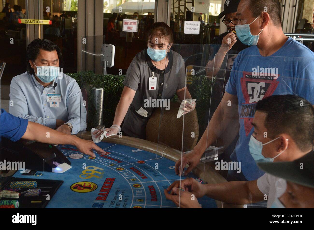 Hawaiian Gardens, United States. 22nd Oct, 2020. A worker sanitizes a partition at one of 45 card tables in what used to be the valet area of Gardens Casino in Hawaiian Gardens, California on Wednesday, October 21, 2020. Partitions and seats are sanitized each time a customer gets up tp prevent the spread of the coronavirus. Card clubs in Los Angeles County reopened in early October with health precautions, drawing a stream of gamblers and expressions of relief from city leaders who have struggled without the key source of tax revenue. Photo by Jim Ruymen/UPI Credit: UPI/Alamy Live News Stock Photo