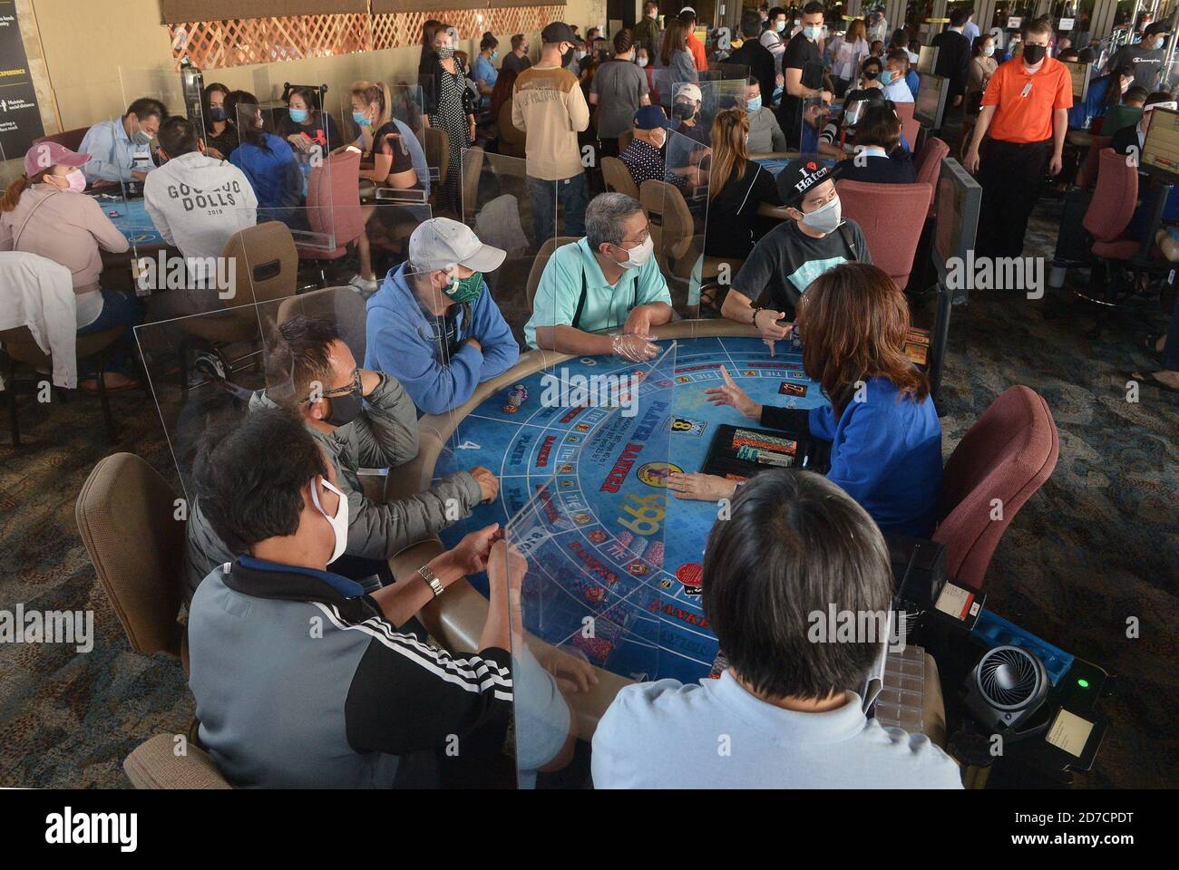 Hawaiian Gardens, United States. 22nd Oct, 2020. Patrons gather at one of 45 card tables in what used to be the valet area of Gardens Casino in Hawaiian Gardens, California on Wednesday, October 21, 2020. Partitions and seats are sanitized each time a customer gets up to prevent the spread of the coronavirus. Card clubs in Los Angeles County reopened in early October with health precautions, drawing a stream of gamblers and expressions of relief from city leaders who have struggled without the key source of tax revenue. Photo by Jim Ruymen/UPI Credit: UPI/Alamy Live News Stock Photo