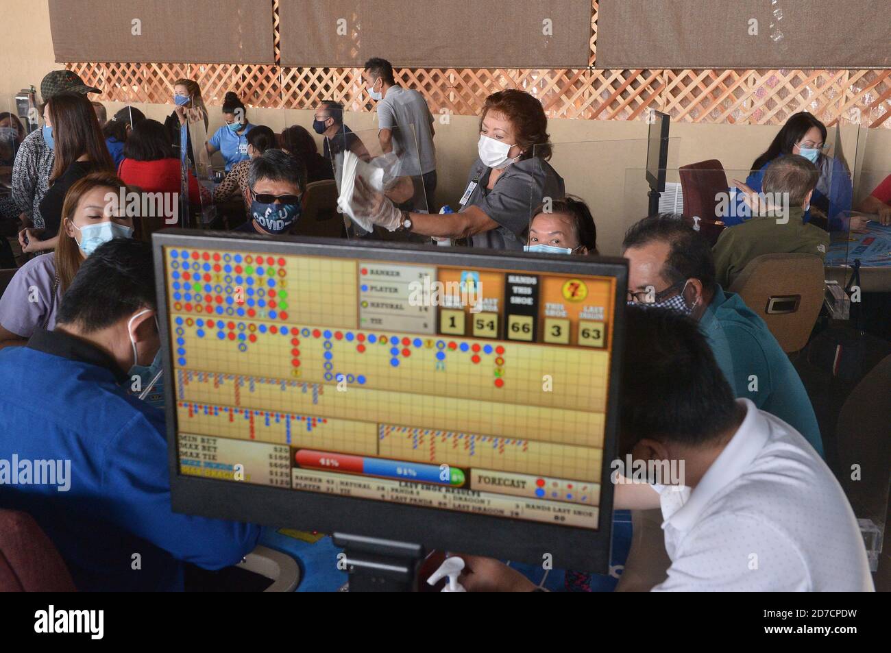 Hawaiian Gardens, United States. 22nd Oct, 2020. A worker sanitizes a partition at one of 45 card tables in what used to be the valet area of Gardens Casino in Hawaiian Gardens, California on Wednesday, October 21, 2020. Partitions and seats are sanitized each time a customer gets up tp prevent the spread of the coronavirus. Card clubs in Los Angeles County reopened in early October with health precautions, drawing a stream of gamblers and expressions of relief from city leaders who have struggled without the key source of tax revenue. Photo by Jim Ruymen/UPI Credit: UPI/Alamy Live News Stock Photo