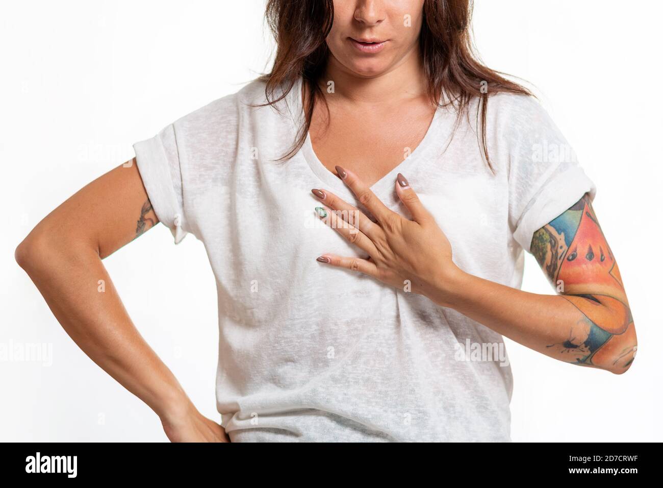 World heart day. A young woman with a tattoo on her arm grabs her chest.  White background. Close up. The concept of heart disease Stock Photo - Alamy