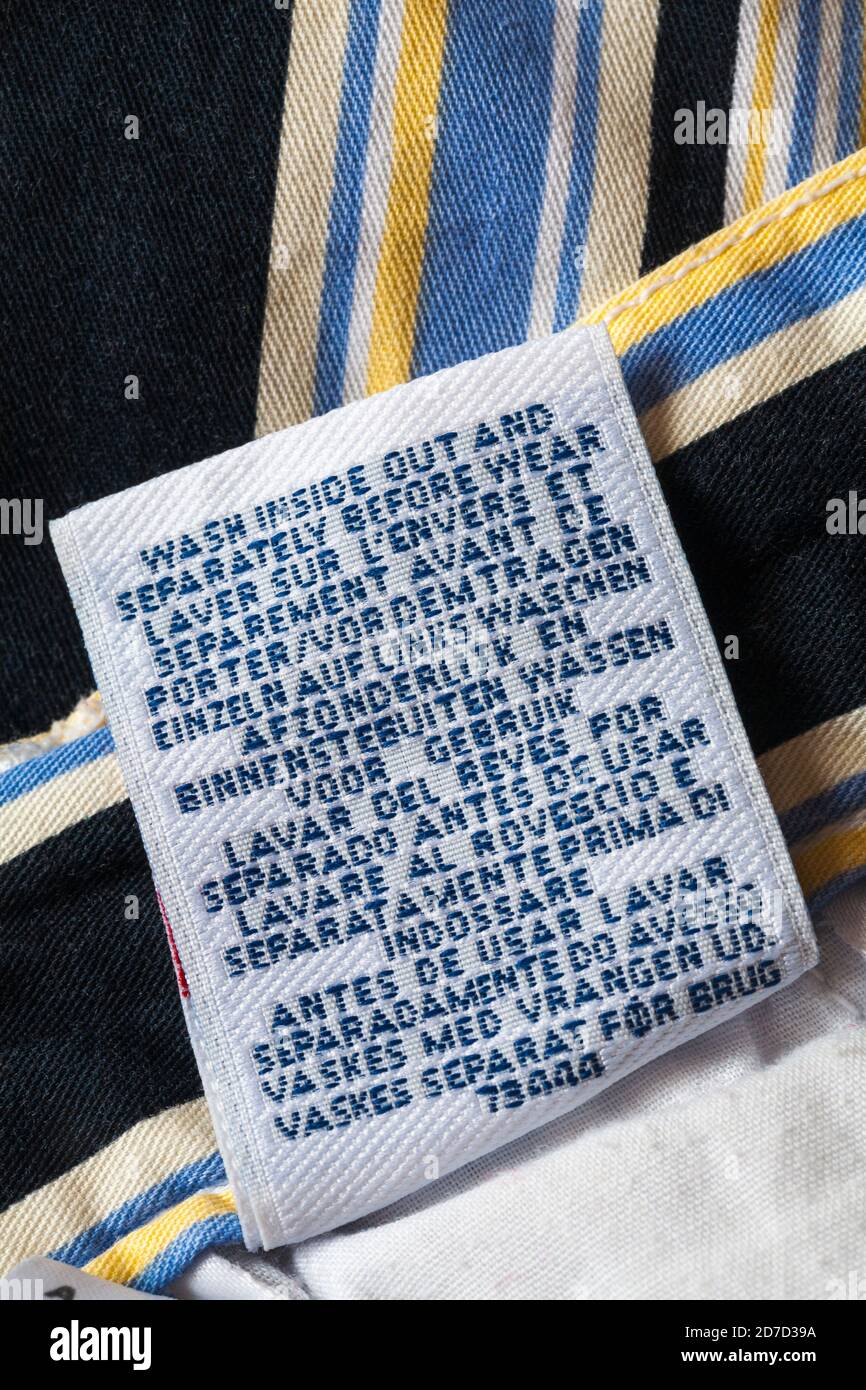 wash inside out and separately before wear in many different languages - washing care instructions on label in pair of Canda women's shorts Stock Photo