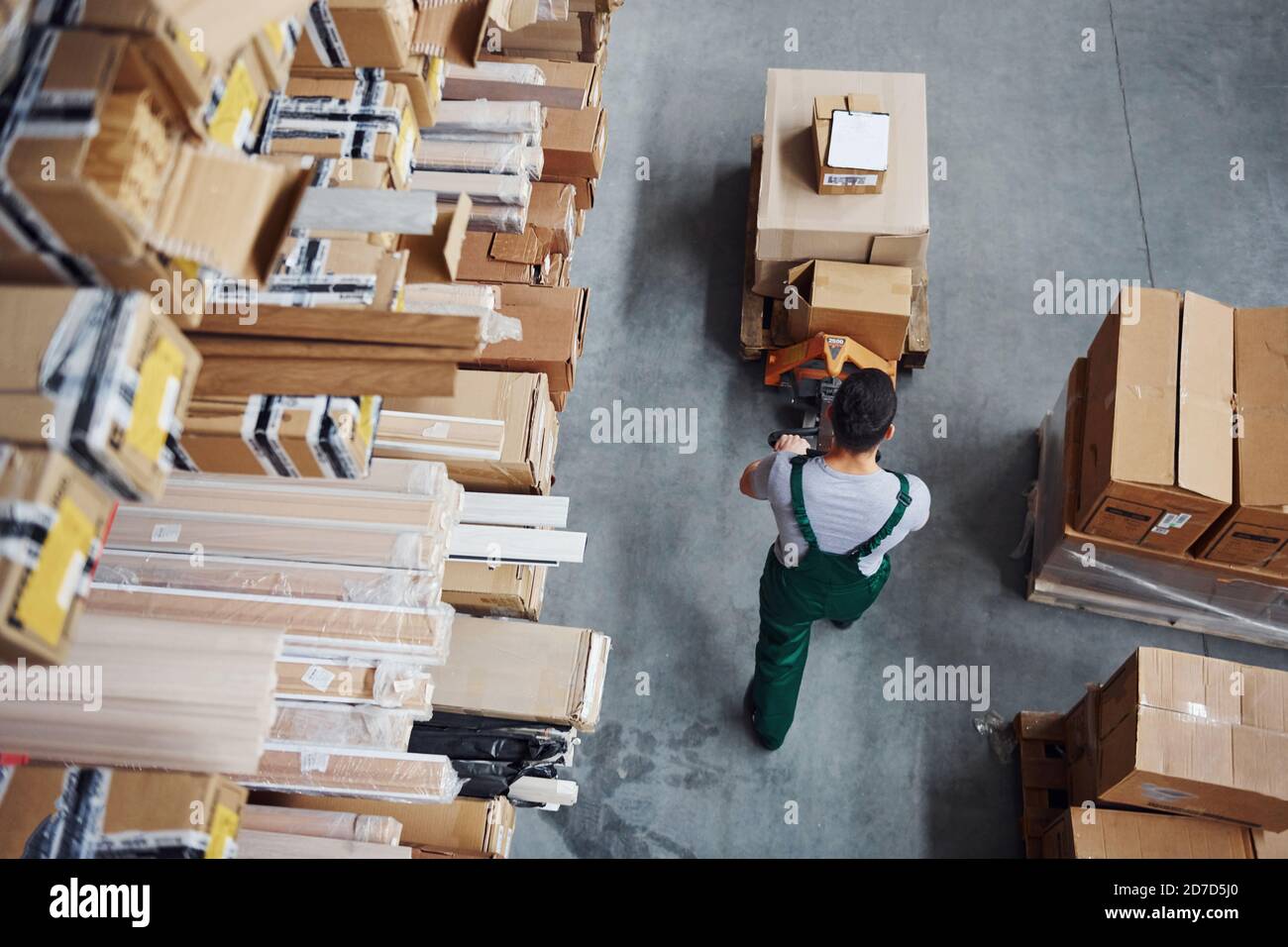 Top view of male worker in warehouse with pallet truck Stock Photo - Alamy