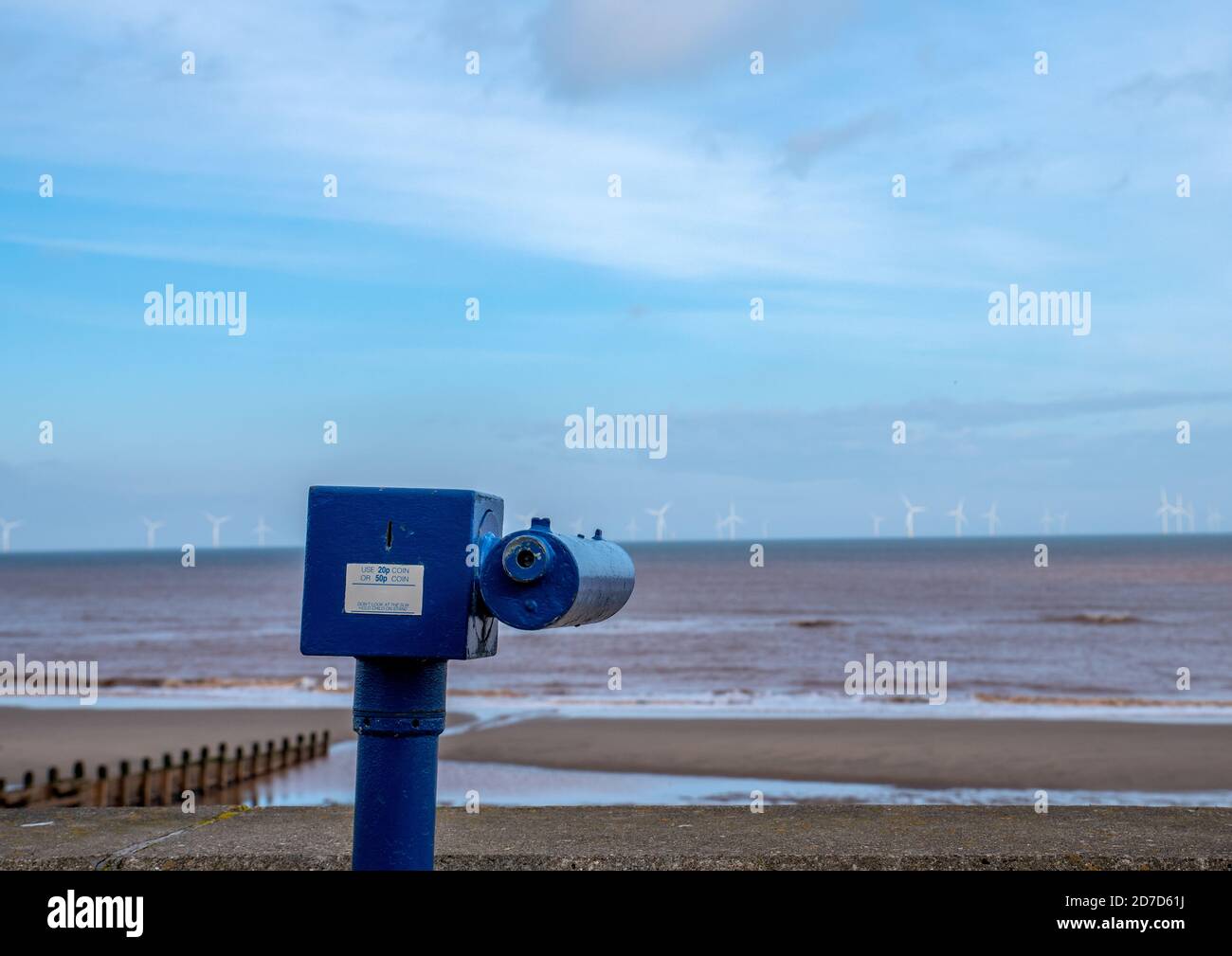 Coin operated telescope on the sea front at Withernsea with view of off shore wind farm in the distance. Stock Photo