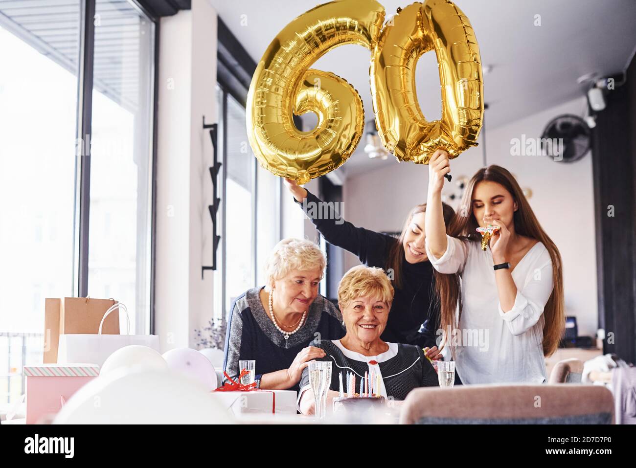 Balloons with number 60. Senior woman with family and friends