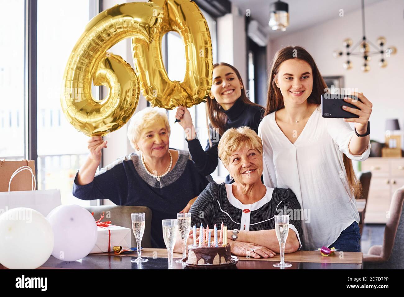 Balloons with number 60. Senior woman with family and friends
