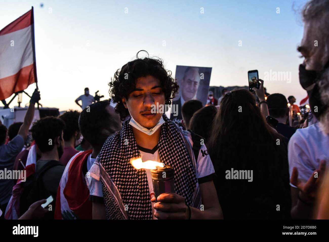 Beirut, Lebanon, 17 October 2020. A man carrying a torch, as a low turn-out of protesters gather on the Charles helou Highway next to the Port of Beirut to mark the anniversary of the Lebanese Thawra, one year after protests began on 17 October 2019 Stock Photo
