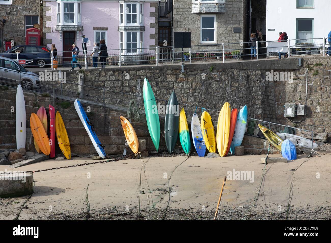 Canoes and kayaks leant up against the harbour wall in Mousehole