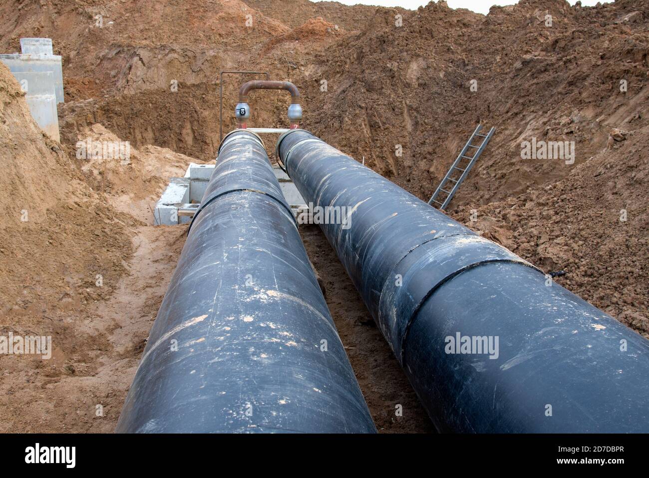 Laying heating pipes in a trench at construction site. Installation