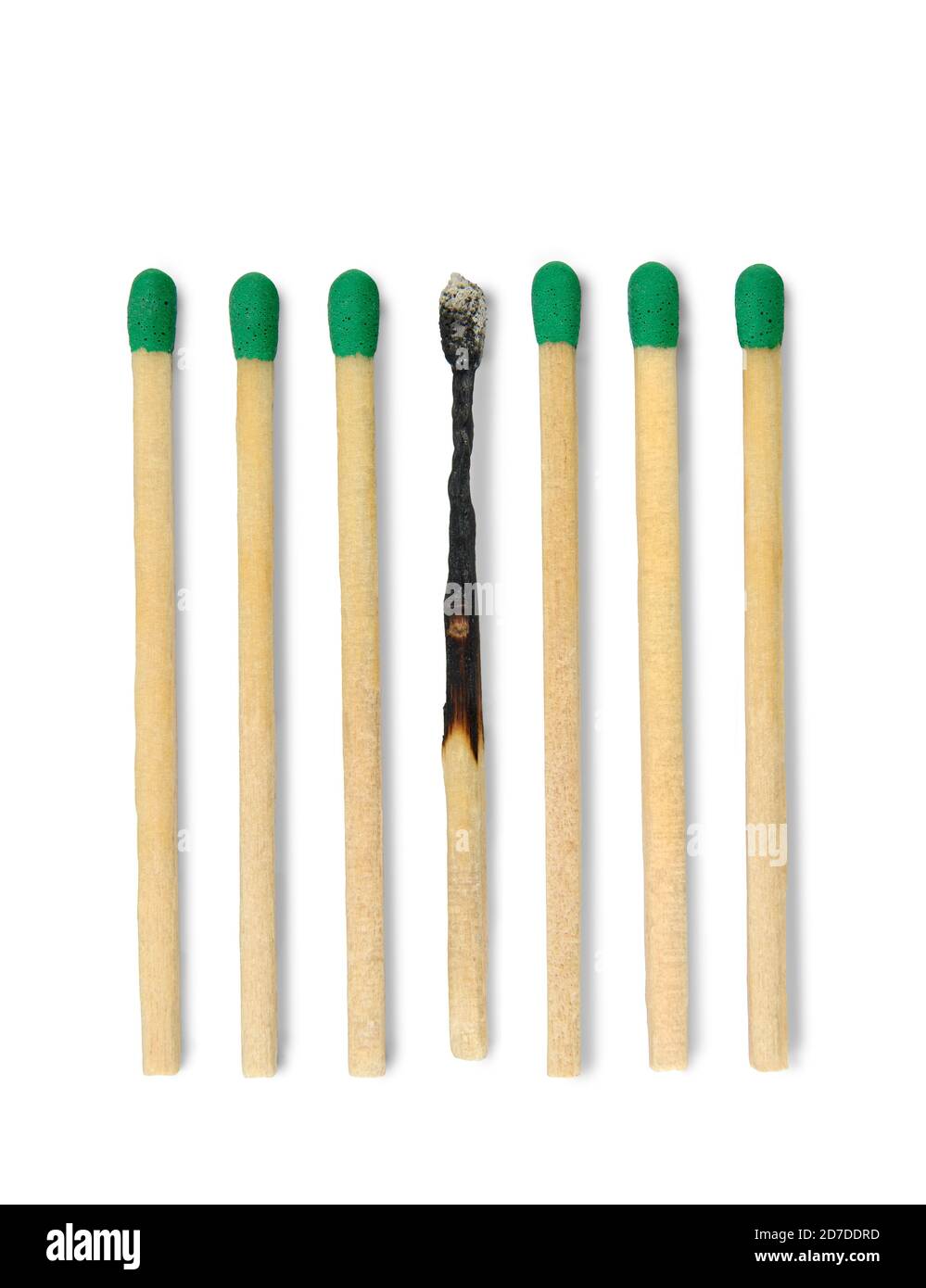 Seven matches aligned one burned in vertical position against white background. Stock Photo
