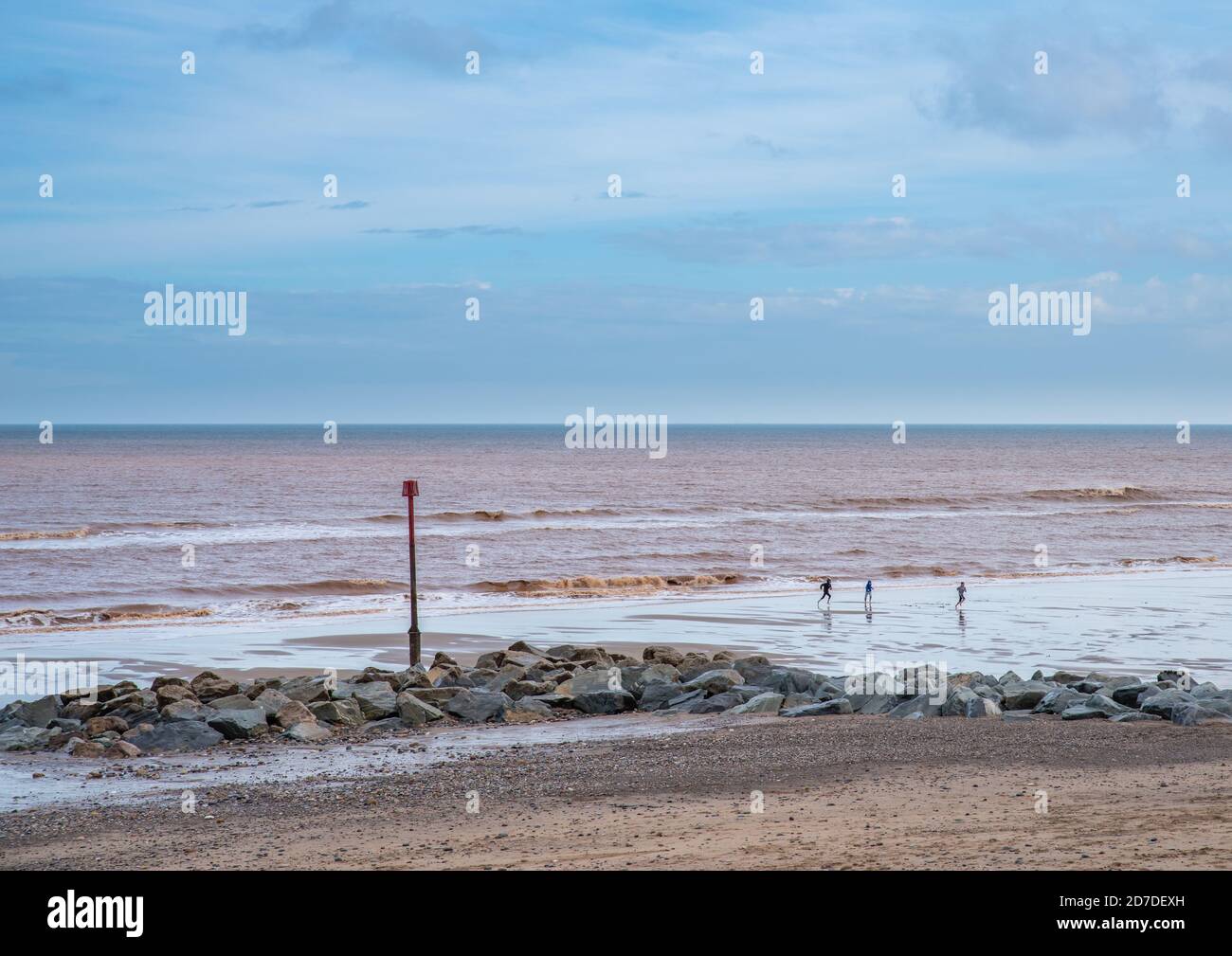 Withernsea, East Yorkshire, England, 20/10/2020 distant view of children playing on the beach