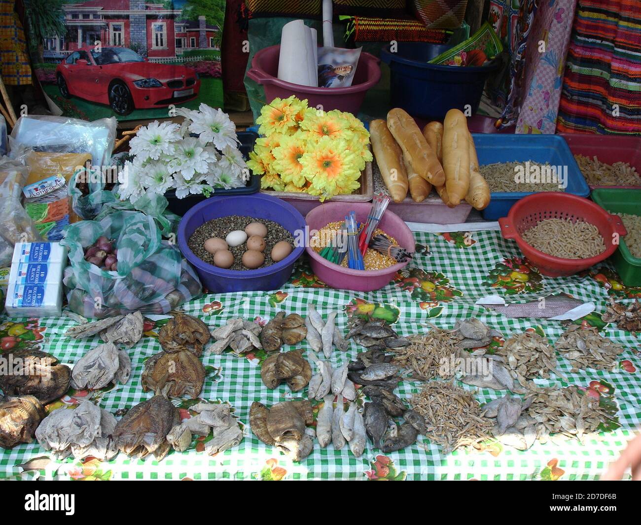 Market stall in a poor Madagascan village selling the necessities of life and plastic flowers. Stock Photo