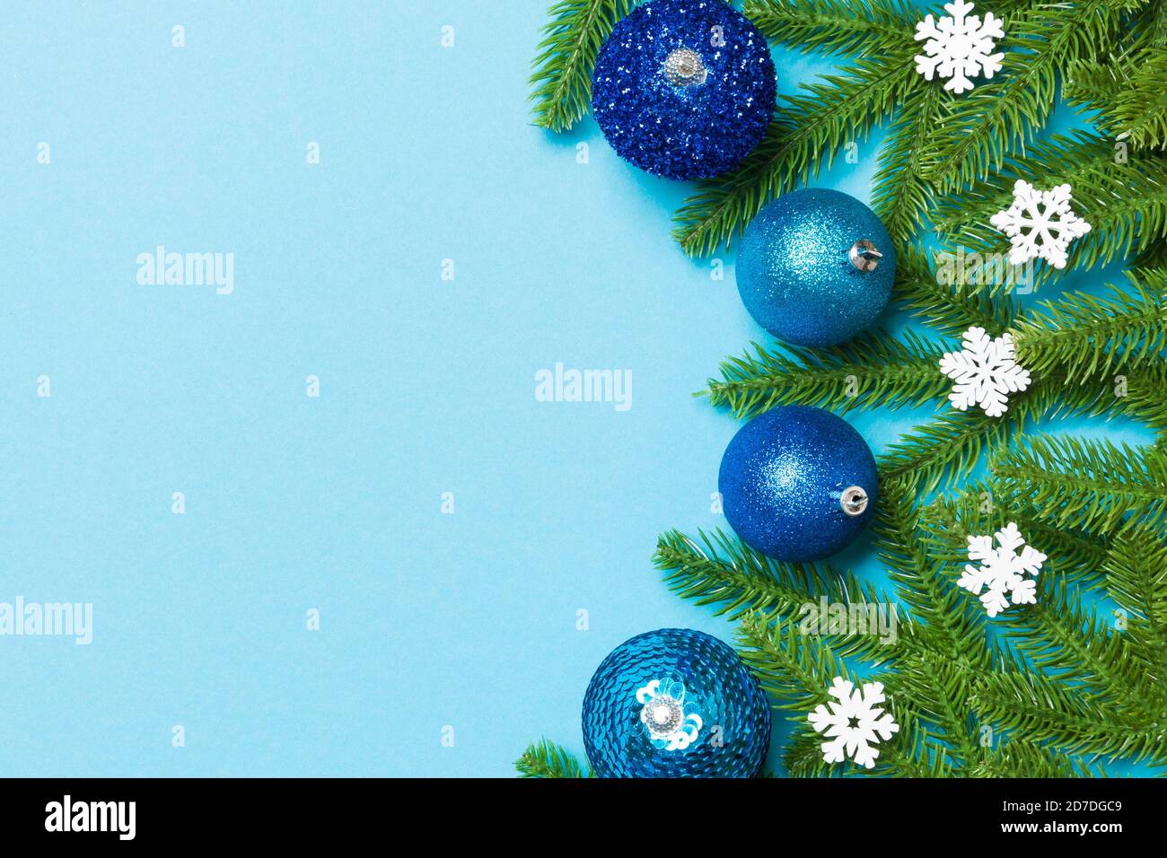 Christmas composition made of fir tree, balls and different decorations on colorful background. Top view of New Year Advent concept with empty space f Stock Photo