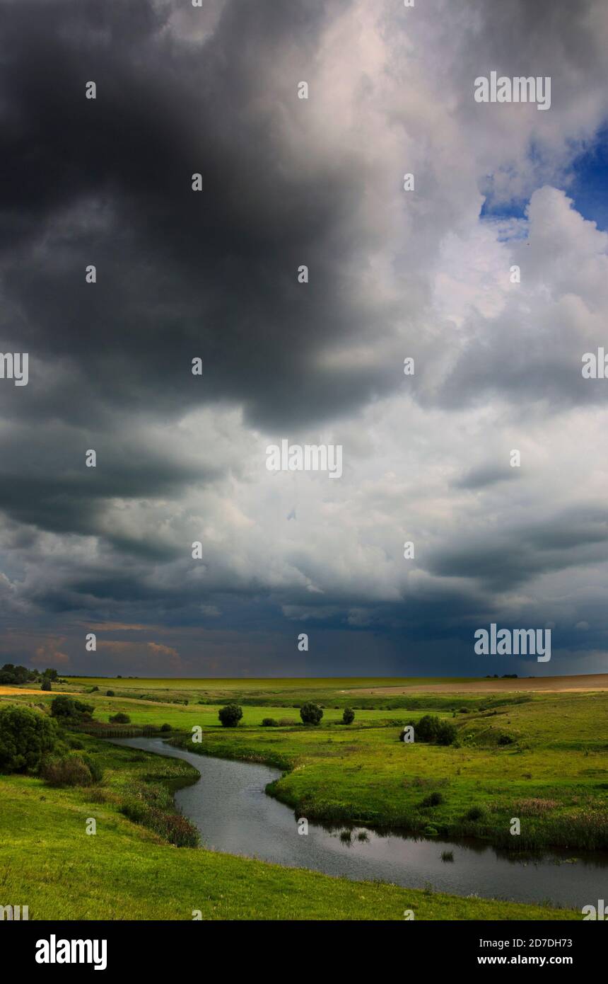 Dark stormy clouds over the fields and meadows Stock Photo - Alamy